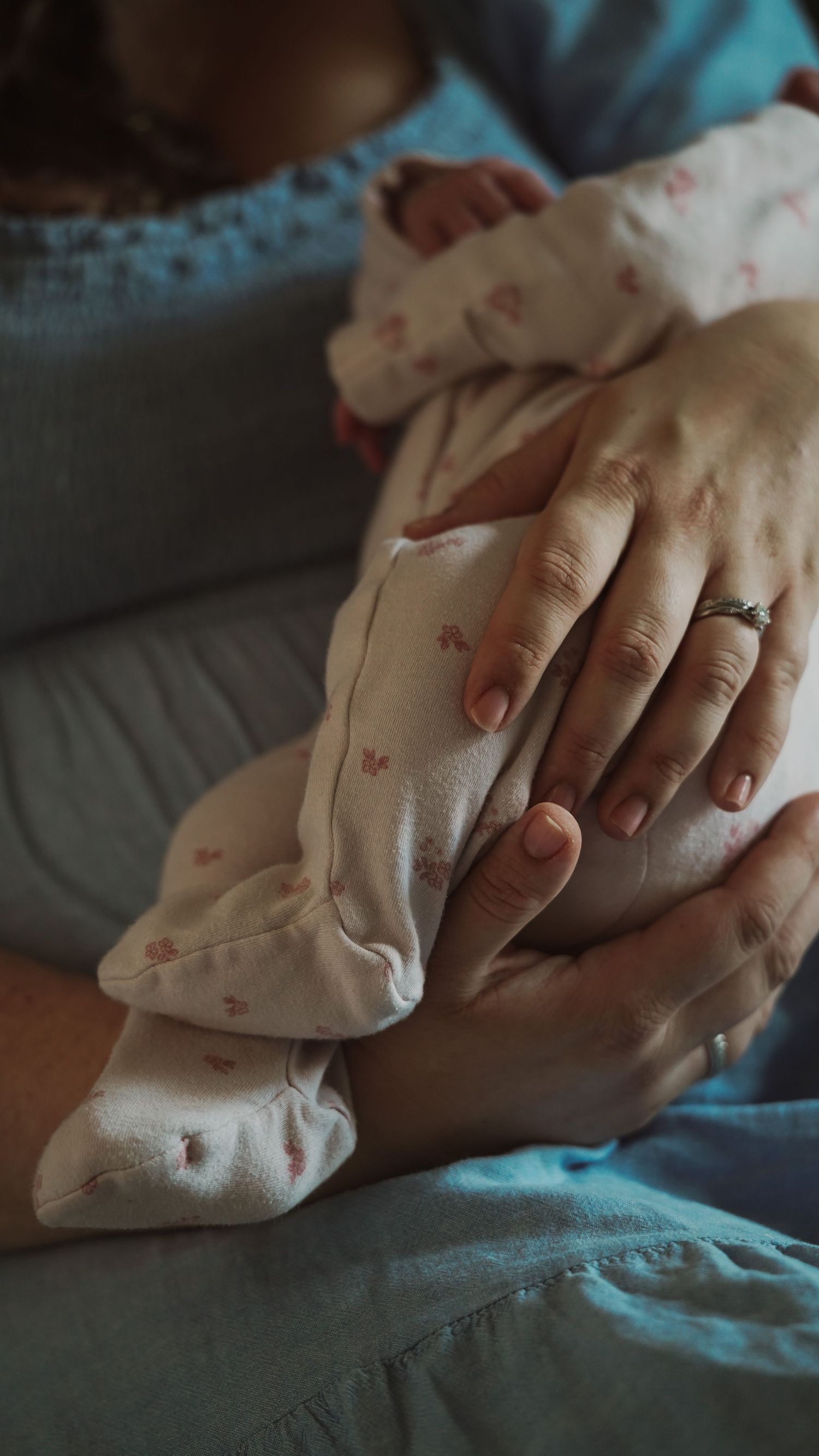 Newborn baby, at home, natural light photograph. Mother holds baby. Suffolk.