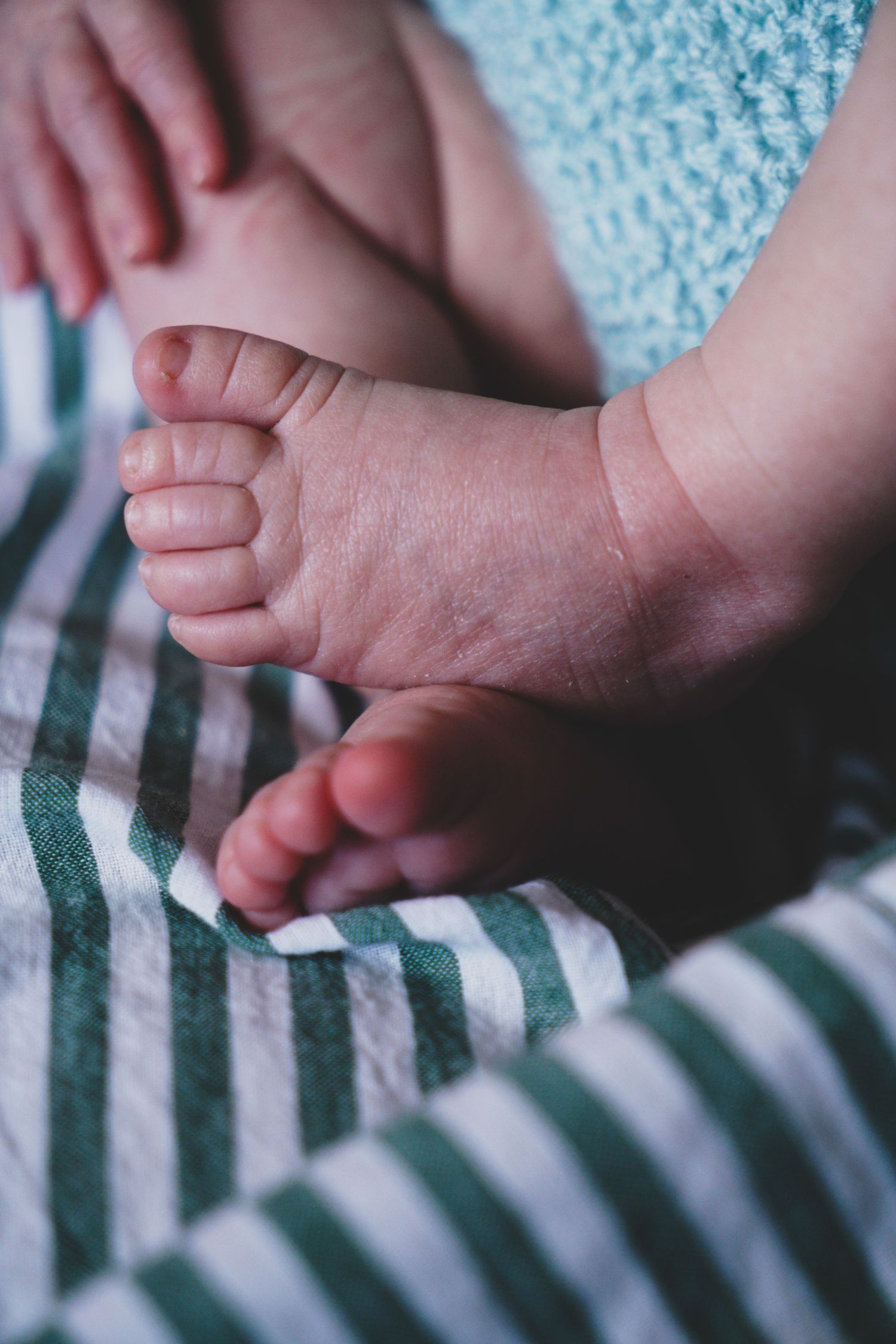 Newborn baby, at home, natural light photograph. Tiny feet.