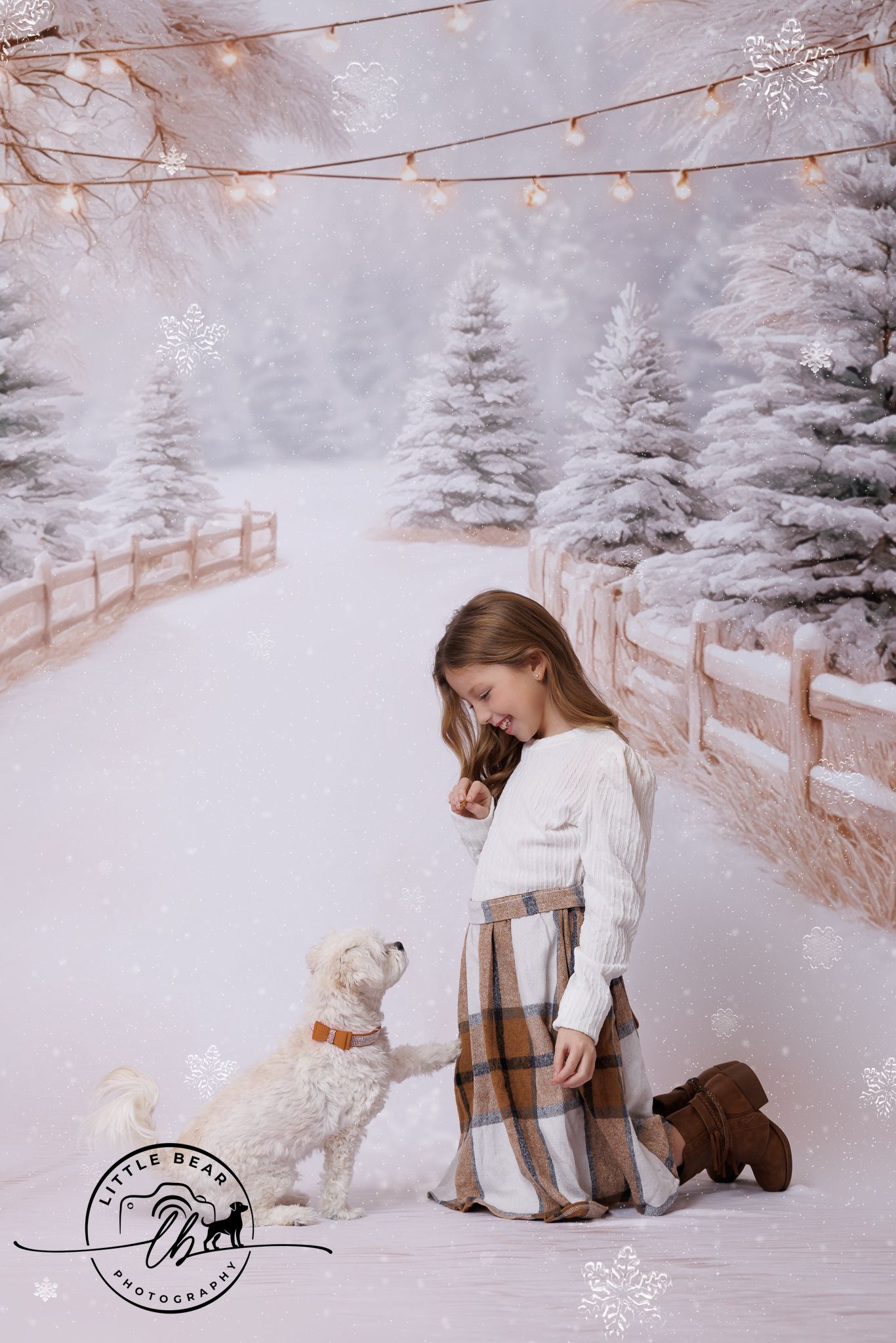 A young girl in a plaid skirt kneels in a snowy winter scene with a white fluffy dog and snow-covered trees.