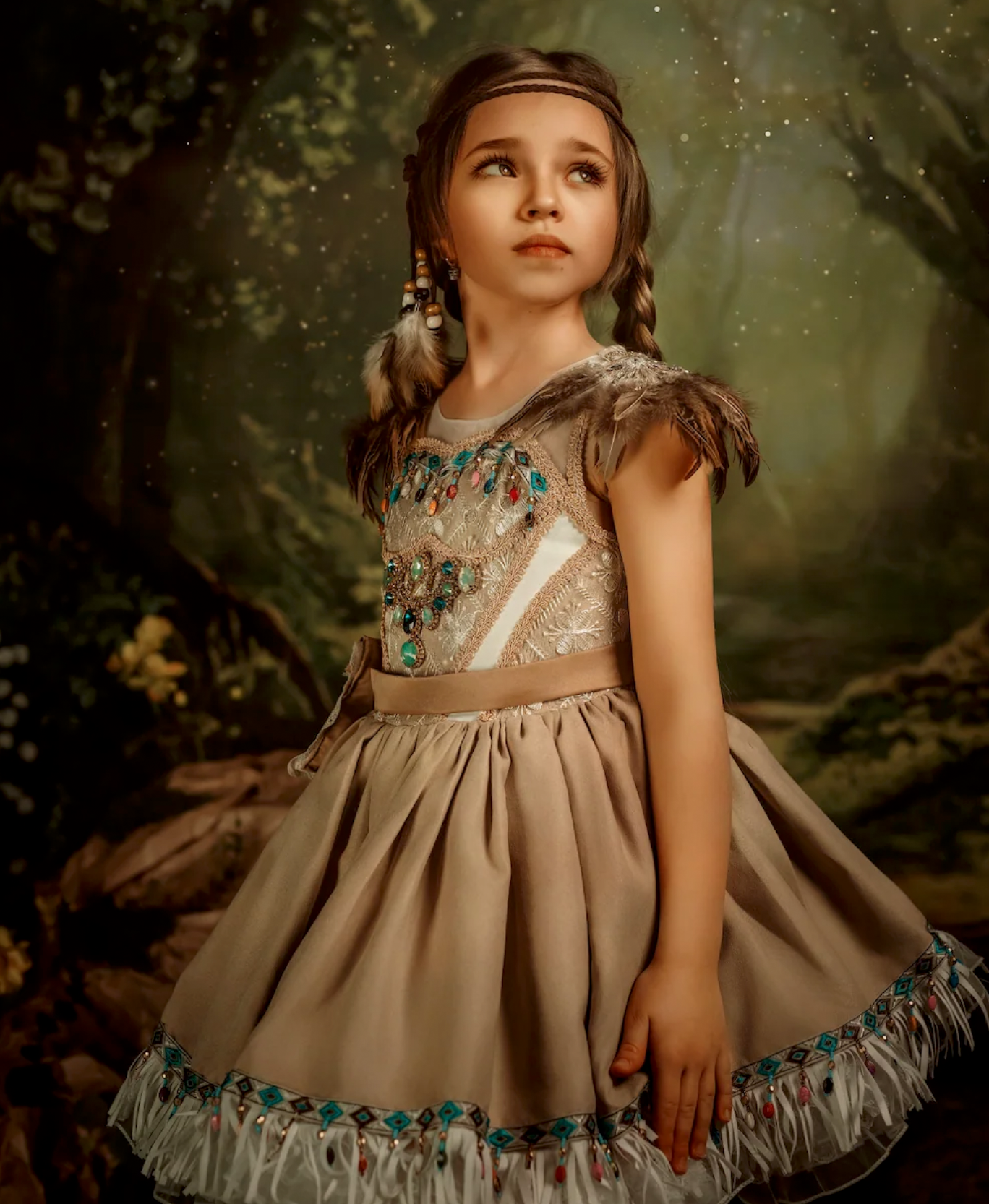 Young girl in a beaded tan Native American-inspired dress with feather accents poses in an enchanted forest setting.