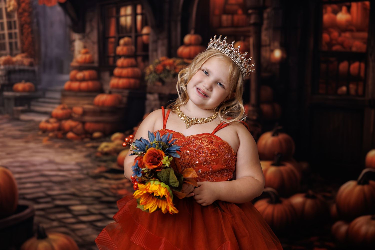 Girl in red sequin dress and tiara holds sunflower bouquet among pumpkins in autumn setting.