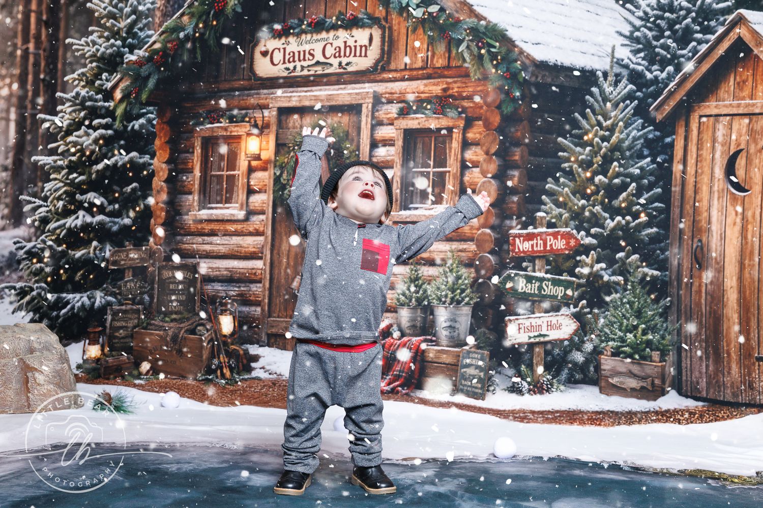 A joyful child plays in snow outside a decorated Santa Claus Cabin log house with Christmas trees and festive holiday decor.