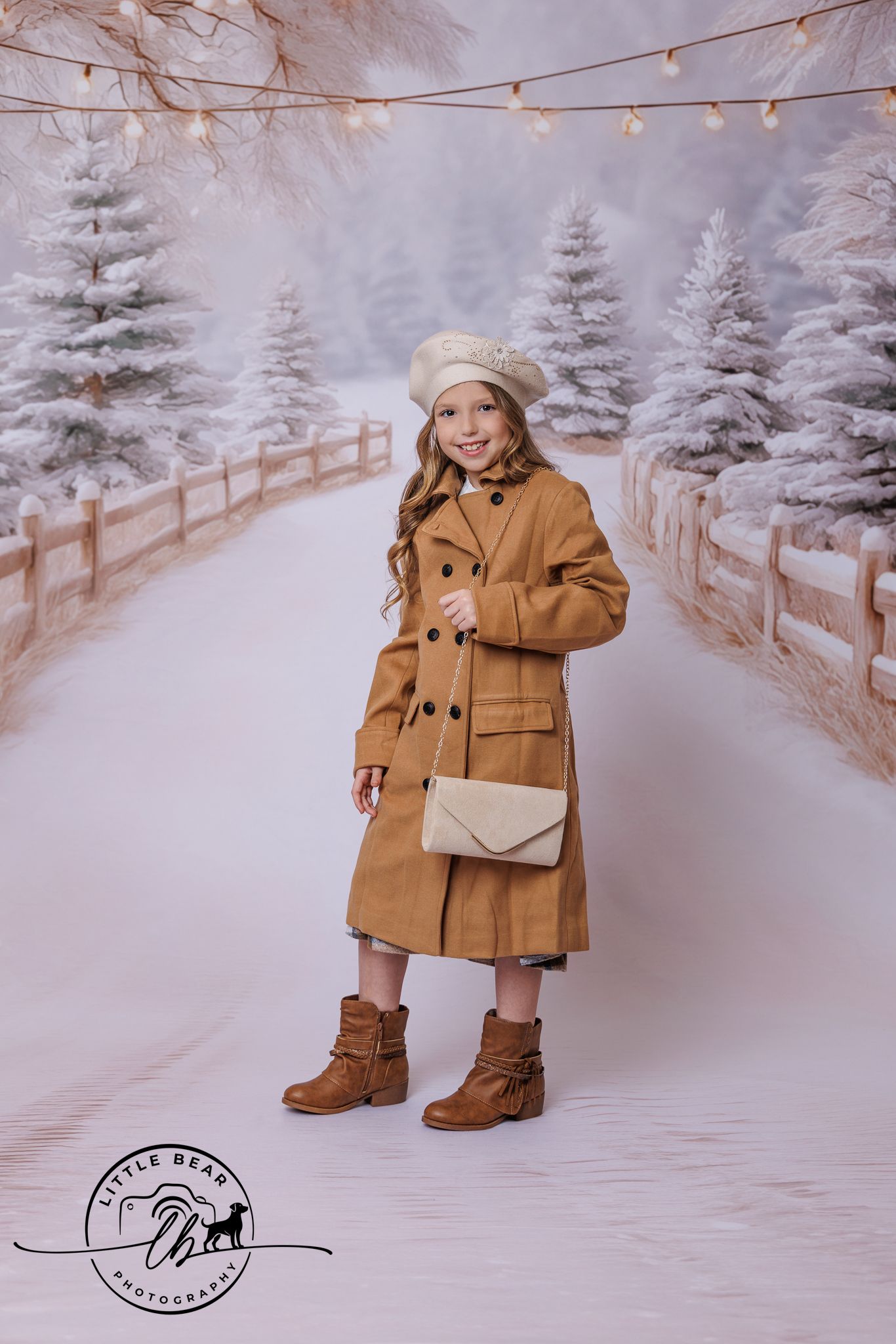 Little girl in camel wool coat and beret holding cream purse in snowy winter backdrop.