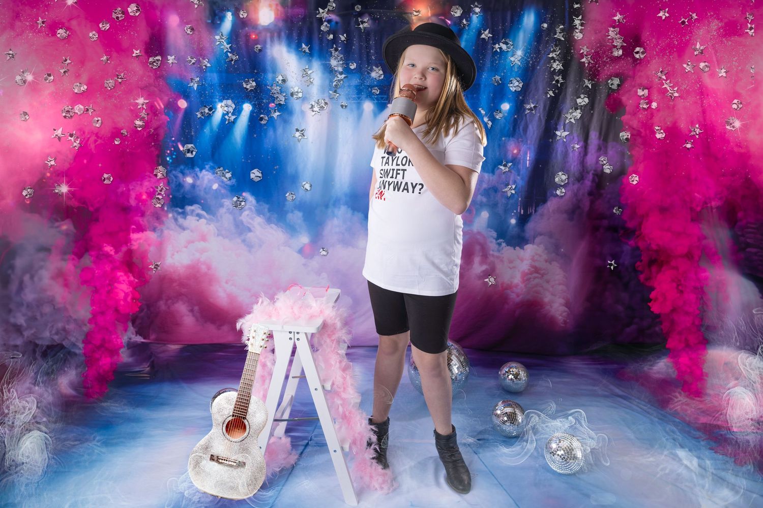 Person in rockstar costume with guitar and microphone on colorful smoke-filled concert stage backdrop.