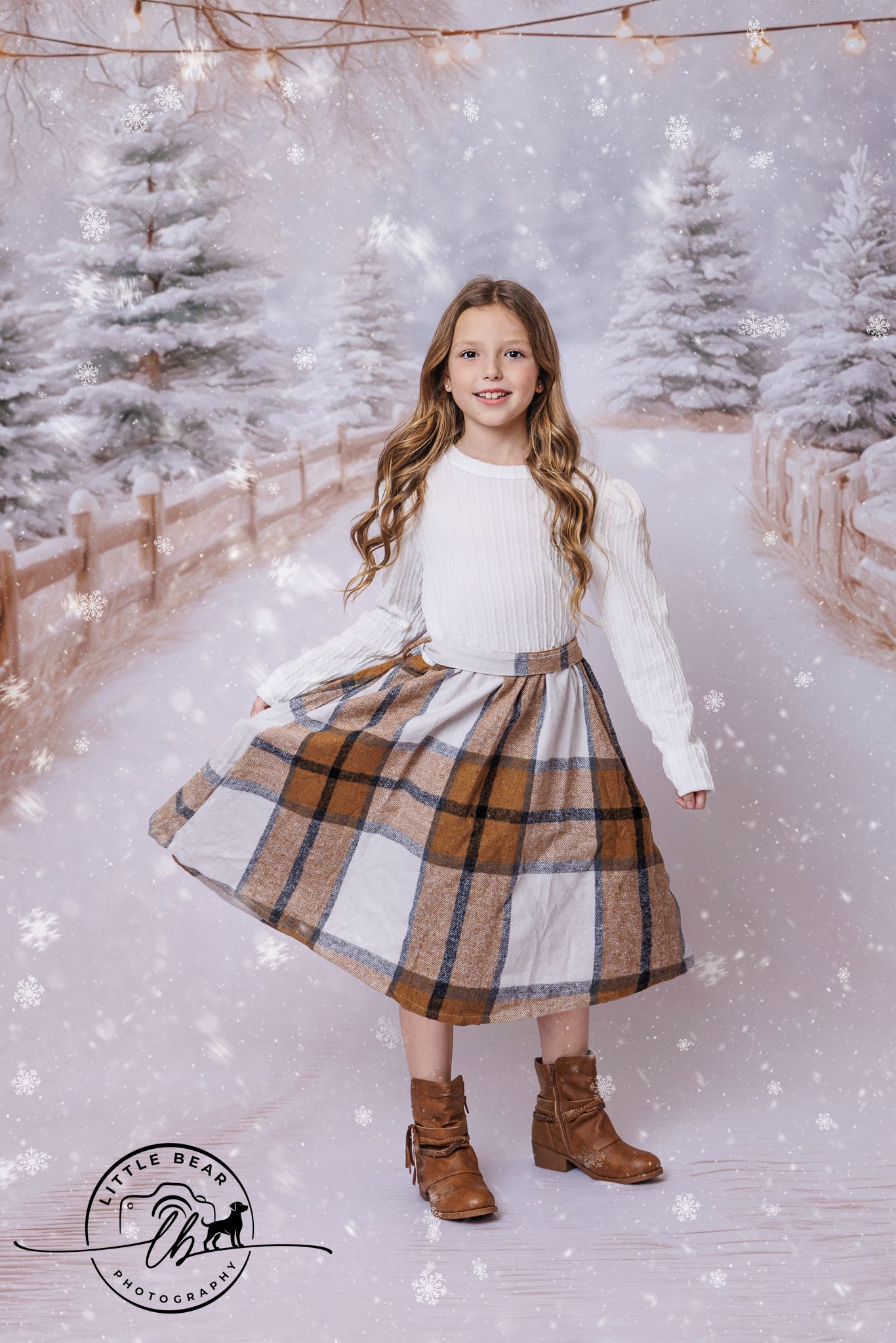 Girl in white sweater and plaid skirt twirling in snowy winter wonderland photography backdrop.
