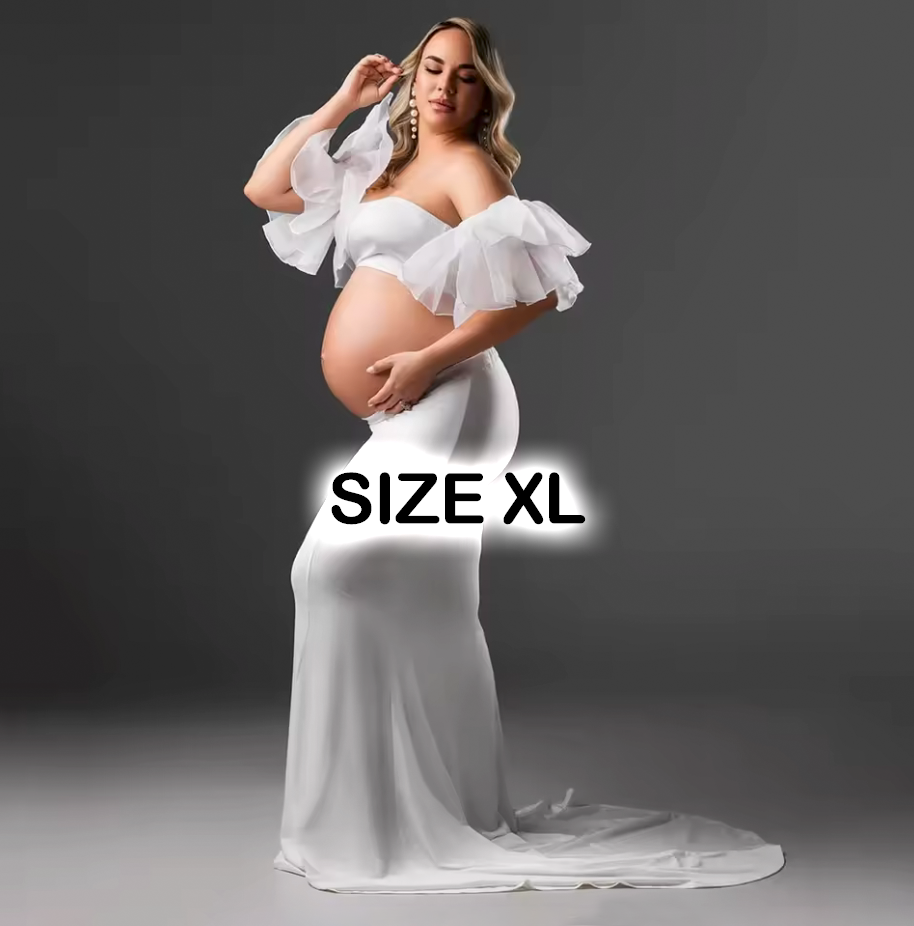 Pregnant woman in white off-shoulder maternity gown, size XL, with ruffled sleeves and elegant train.