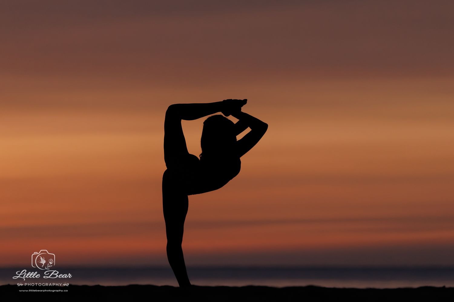 Silhouette of a gymnast performing a graceful backbend pose against a vibrant orange and purple sunset sky.
