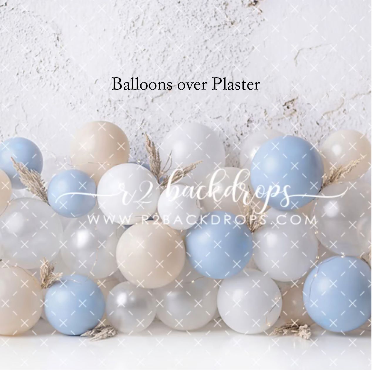 Photography backdrop featuring pastel blue, beige, and silver balloons arranged against a white plaster wall by r2 backdrops.