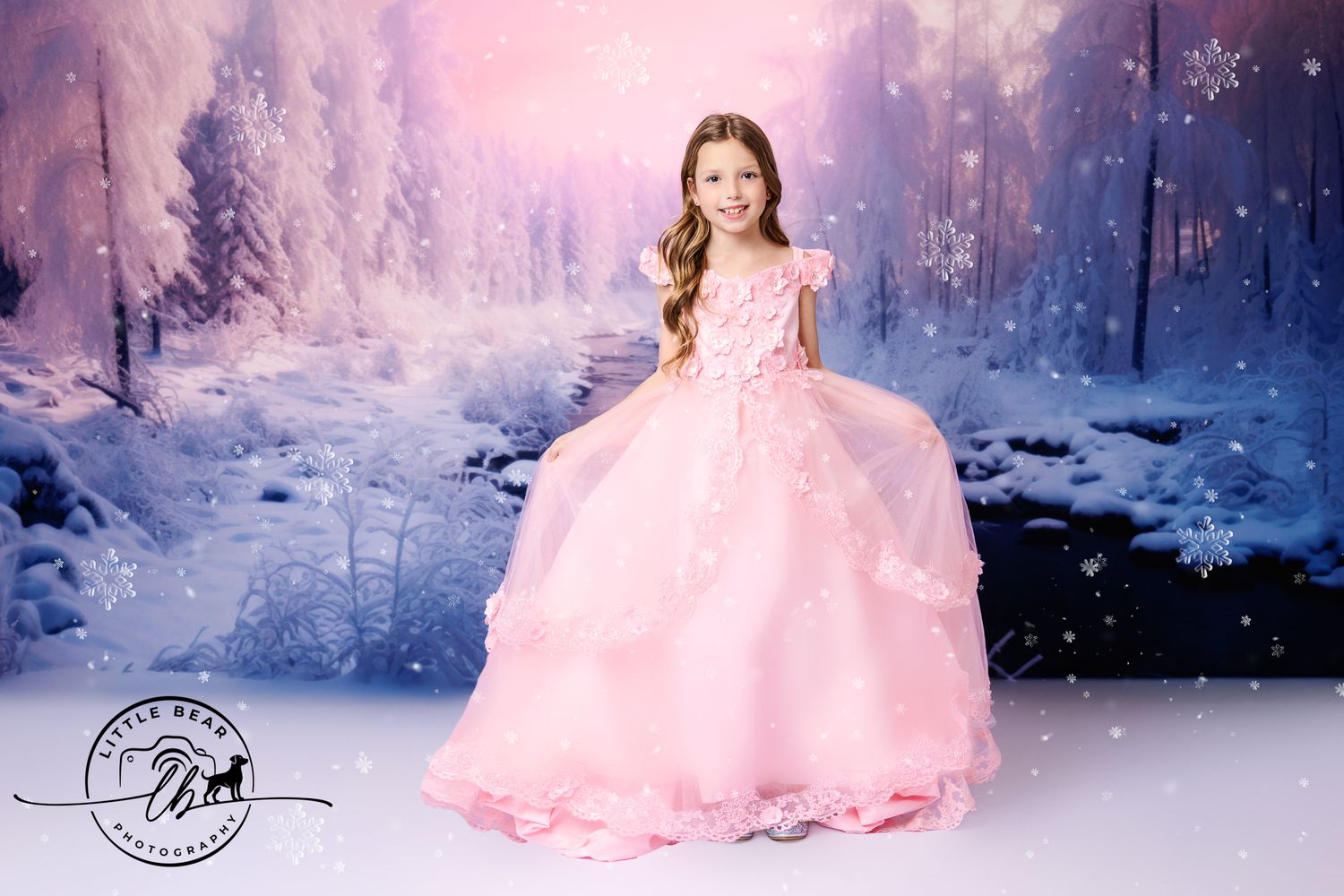 Young girl in pink ball gown stands in enchanted winter forest princess portrait photography.