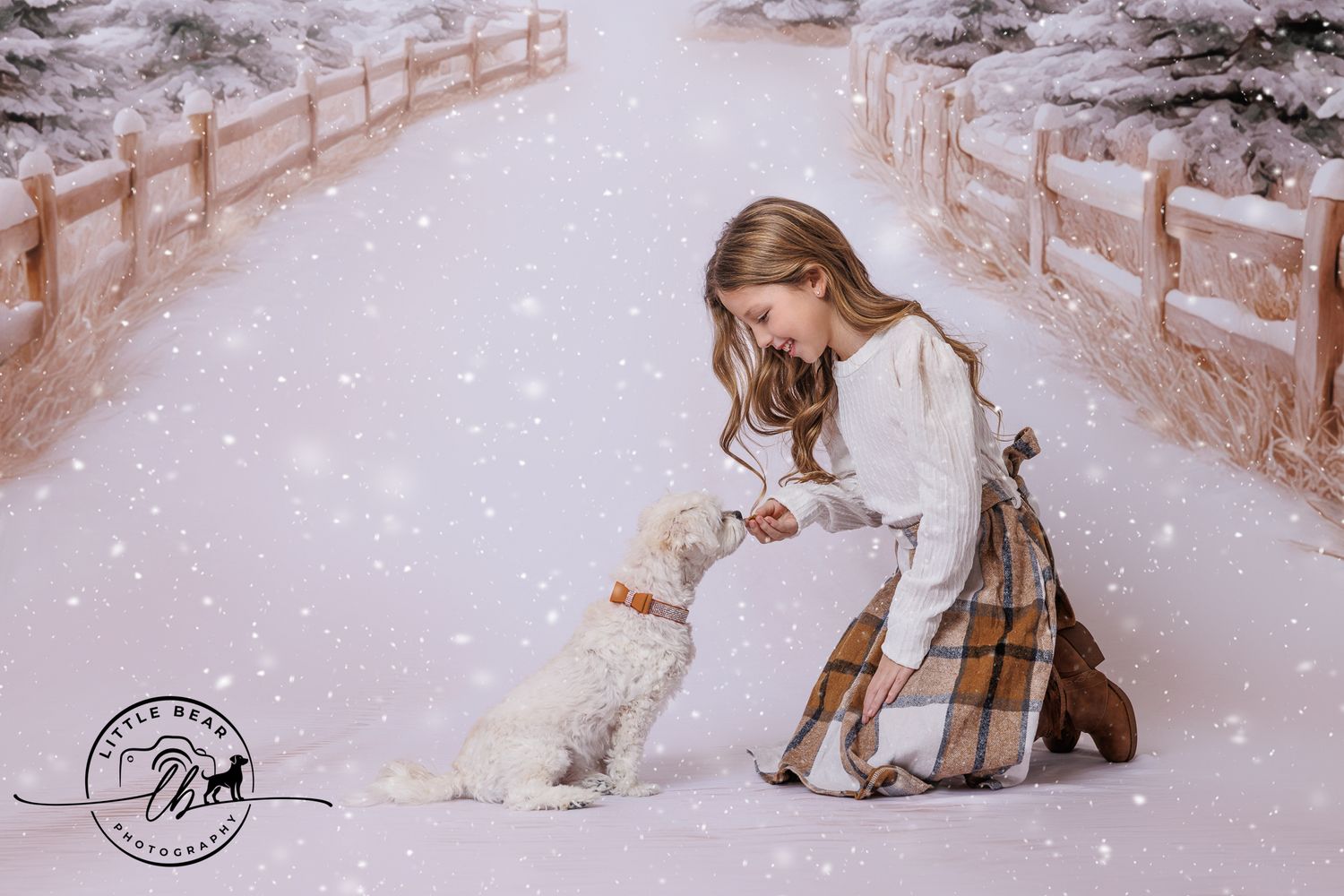A young girl in a plaid skirt kneels to interact with a white dog in a snowy winter scene.