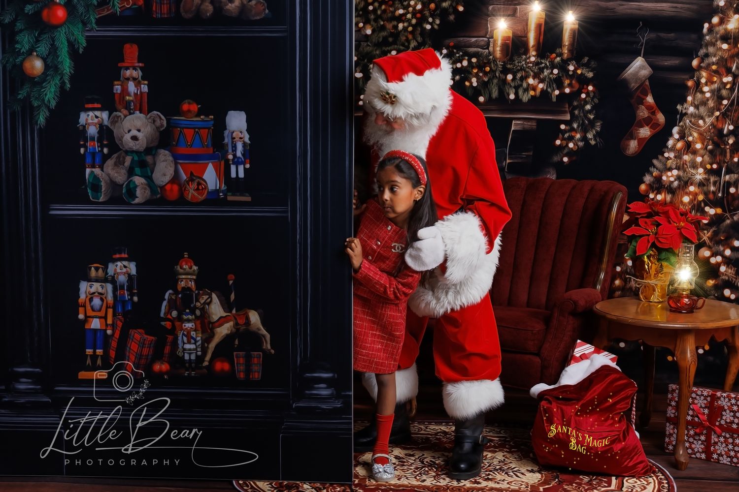 A young girl hugs Santa Claus in a festive Christmas photography studio with nutcrackers and holiday decorations.