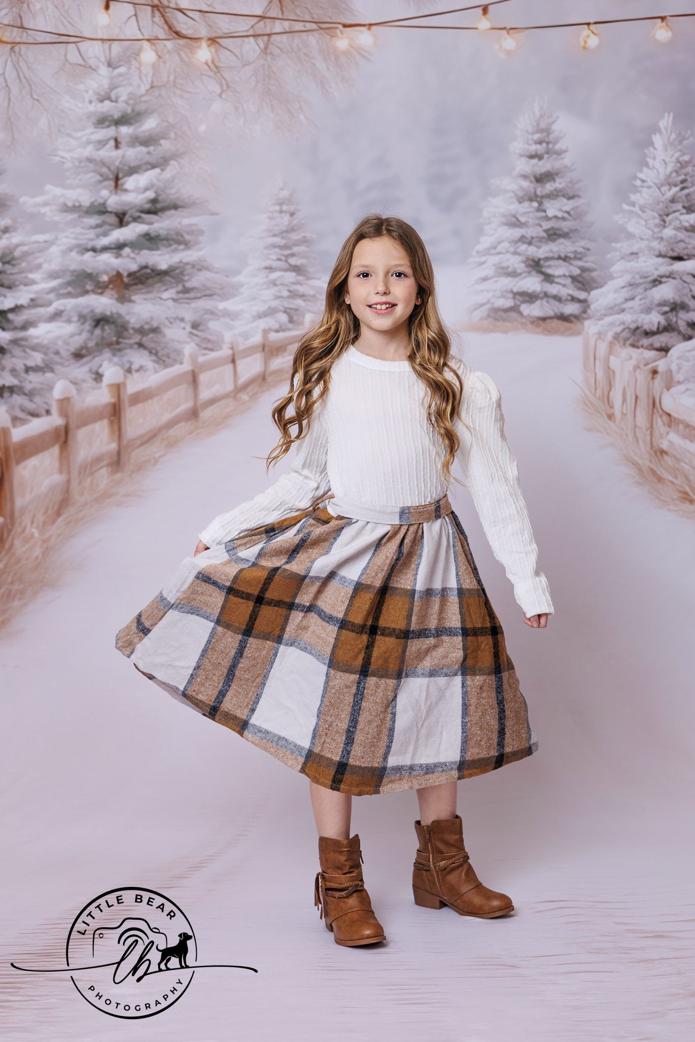 Young girl wearing white top and brown plaid midi skirt posing in snowy winter photo studio.