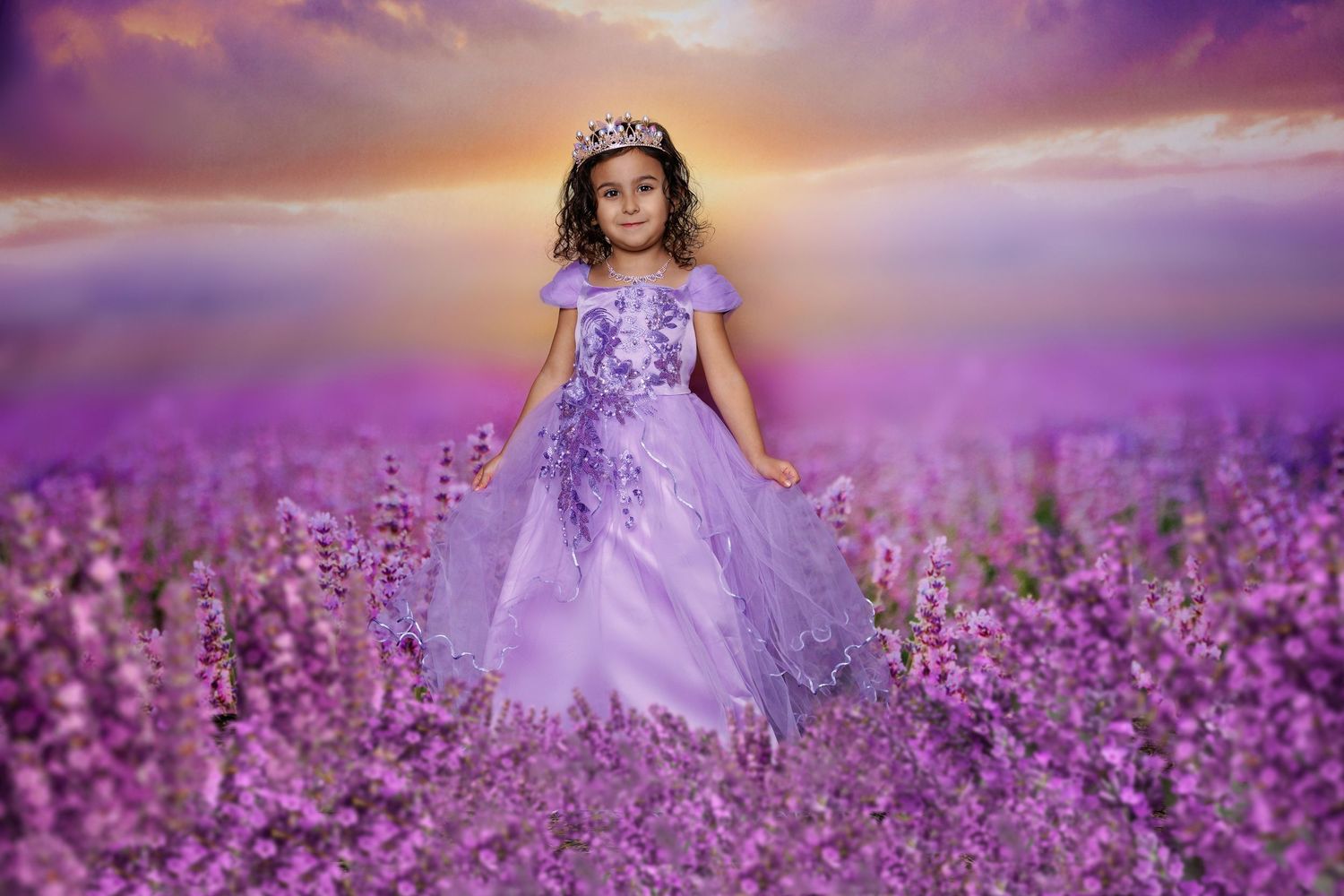 Young girl in a purple princess gown wearing a tiara standing in a lavender field at sunset.
