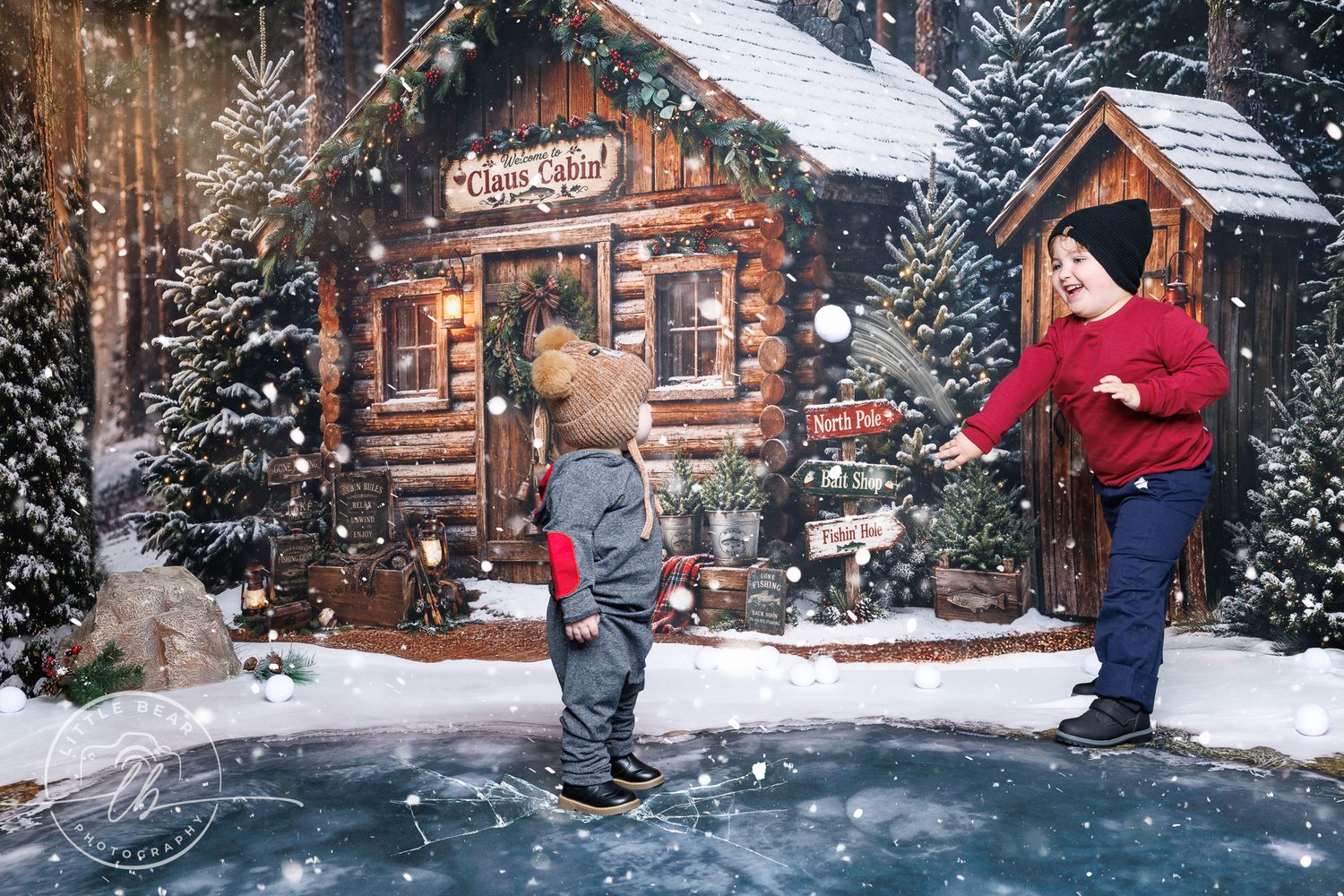 Two children play in snow outside a rustic Christmas cabin with festive decorations and snowy trees.