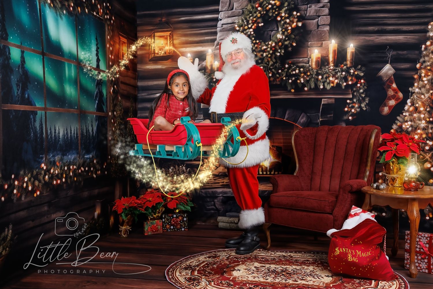A young girl sits in a sleigh with Santa Claus in a festive holiday photo studio setting with Christmas lights.
