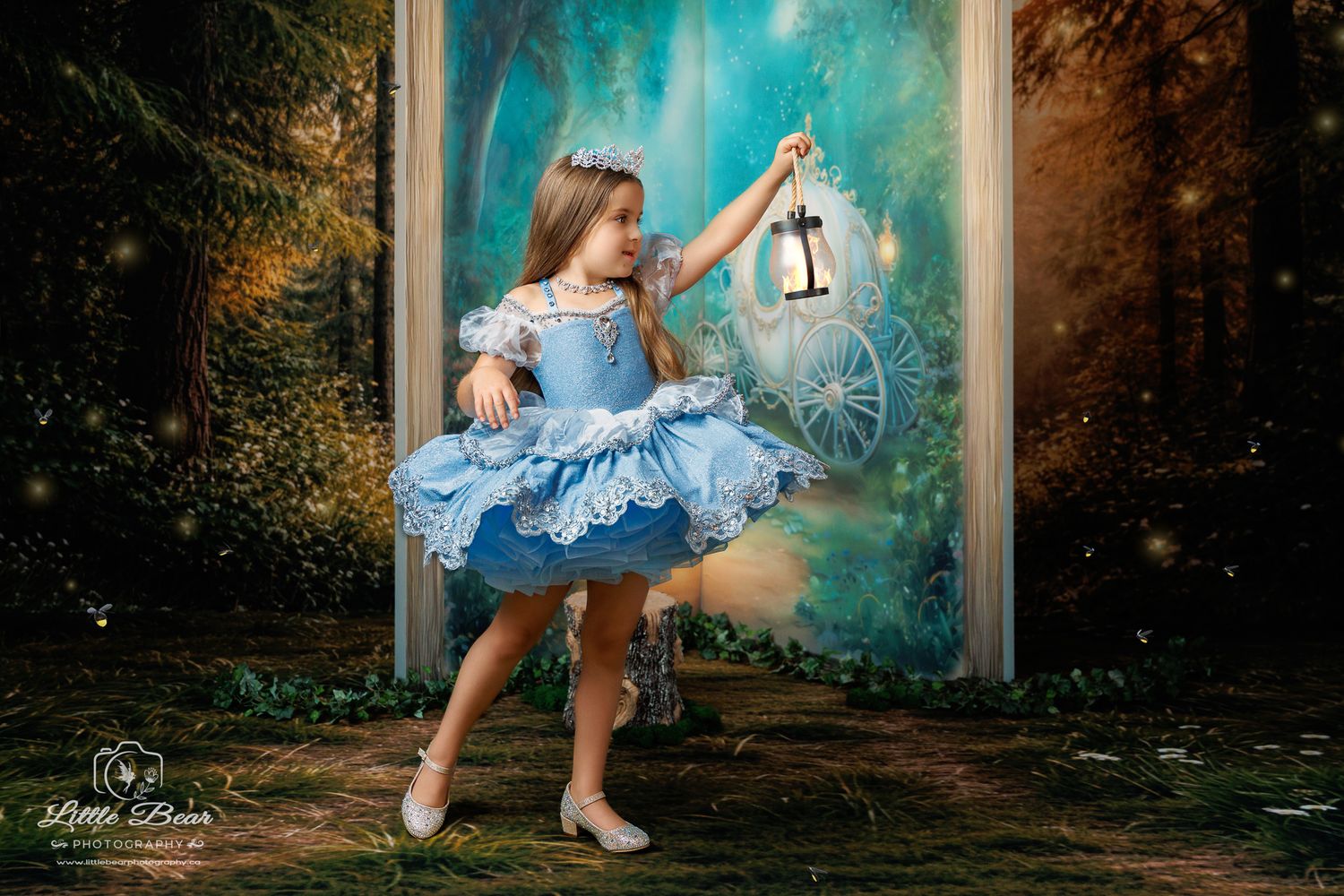 A young girl in a blue Cinderella dress holds a lantern in an enchanted forest with a fairy tale carriage backdrop.