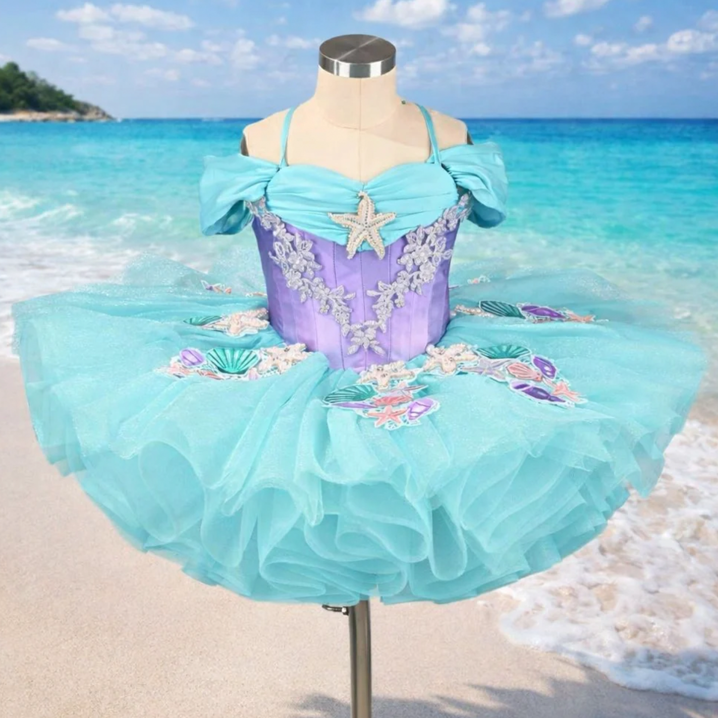 Aqua and purple mermaid-themed ballet tutu dress with starfish embellishments displayed on a mannequin at the beach.