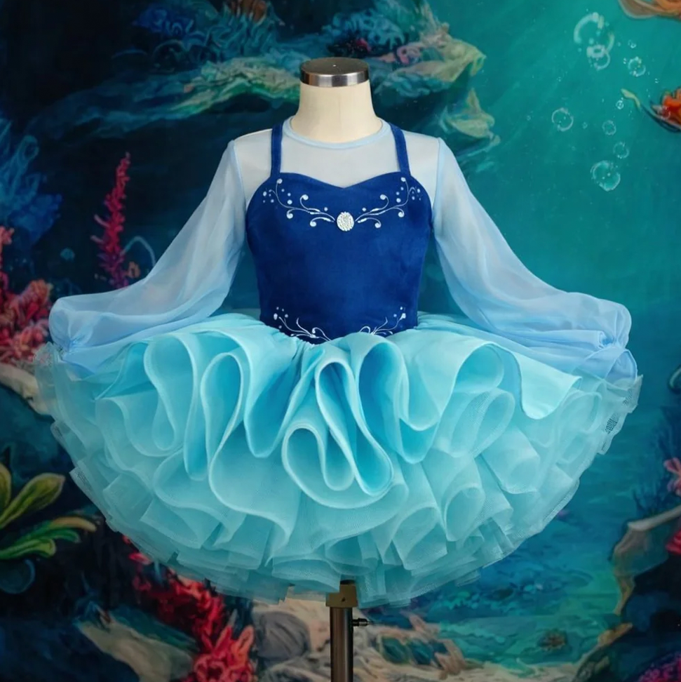 Girls navy and aqua blue ruffled tutu dance dress with sheer sleeves and rhinestone bodice details.