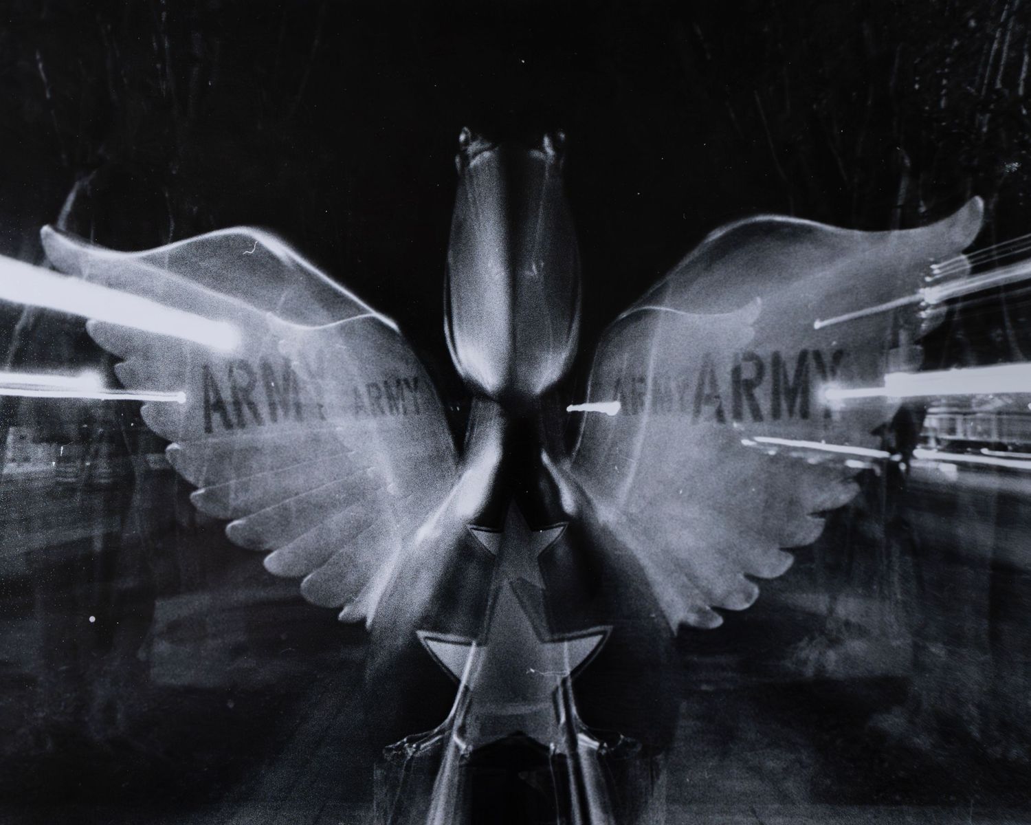 Abstract black and white double exposure of Army eagle insignia with wings spread.