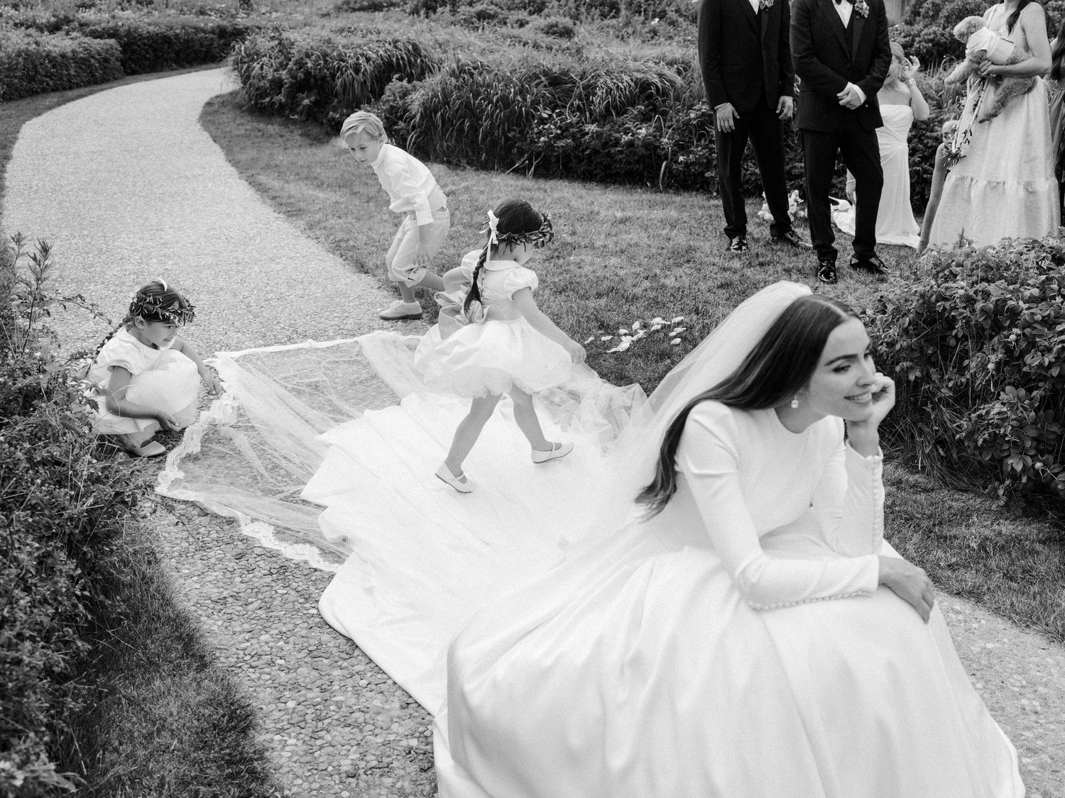 A black and white wedding photo collage showing various romantic moments between a couple in formal attire outdoors.