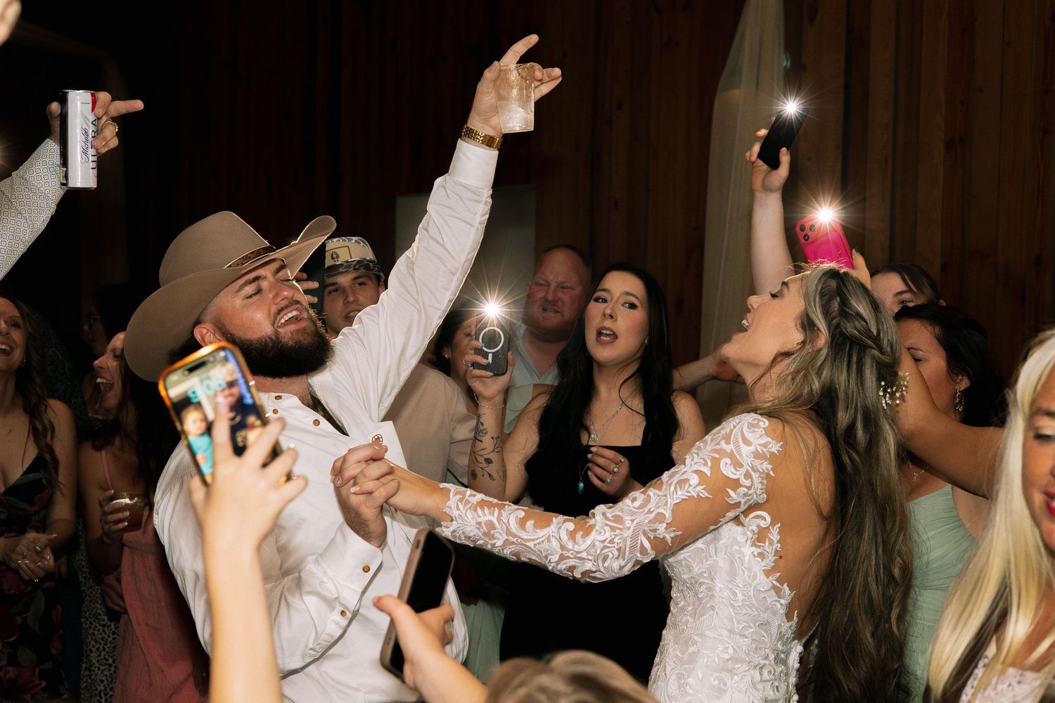 Bride and Groom dancing with friends and family in barn wedding reception with phone flashlights on their wedding day Tampa Florida