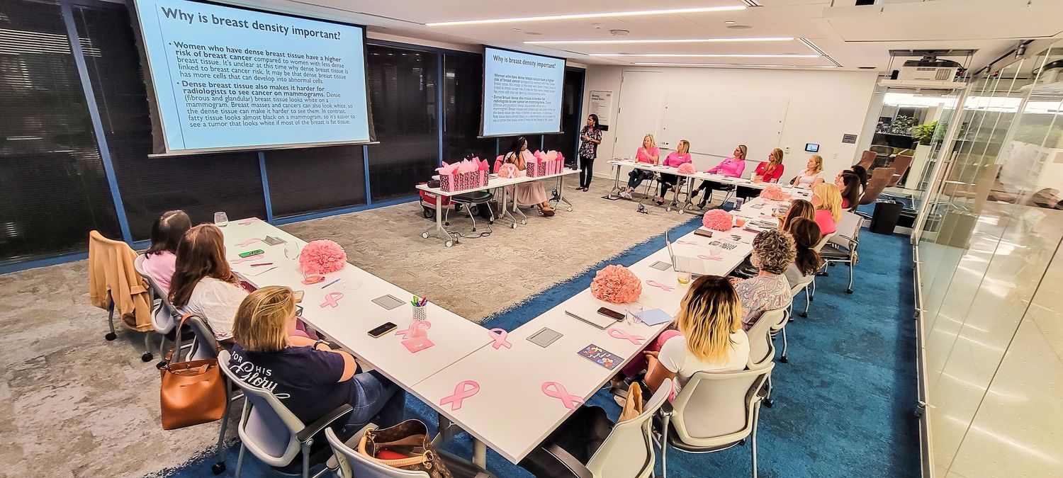 Professional workshop session with attendees seated at tables facing a presentation screen in a modern conference room.
