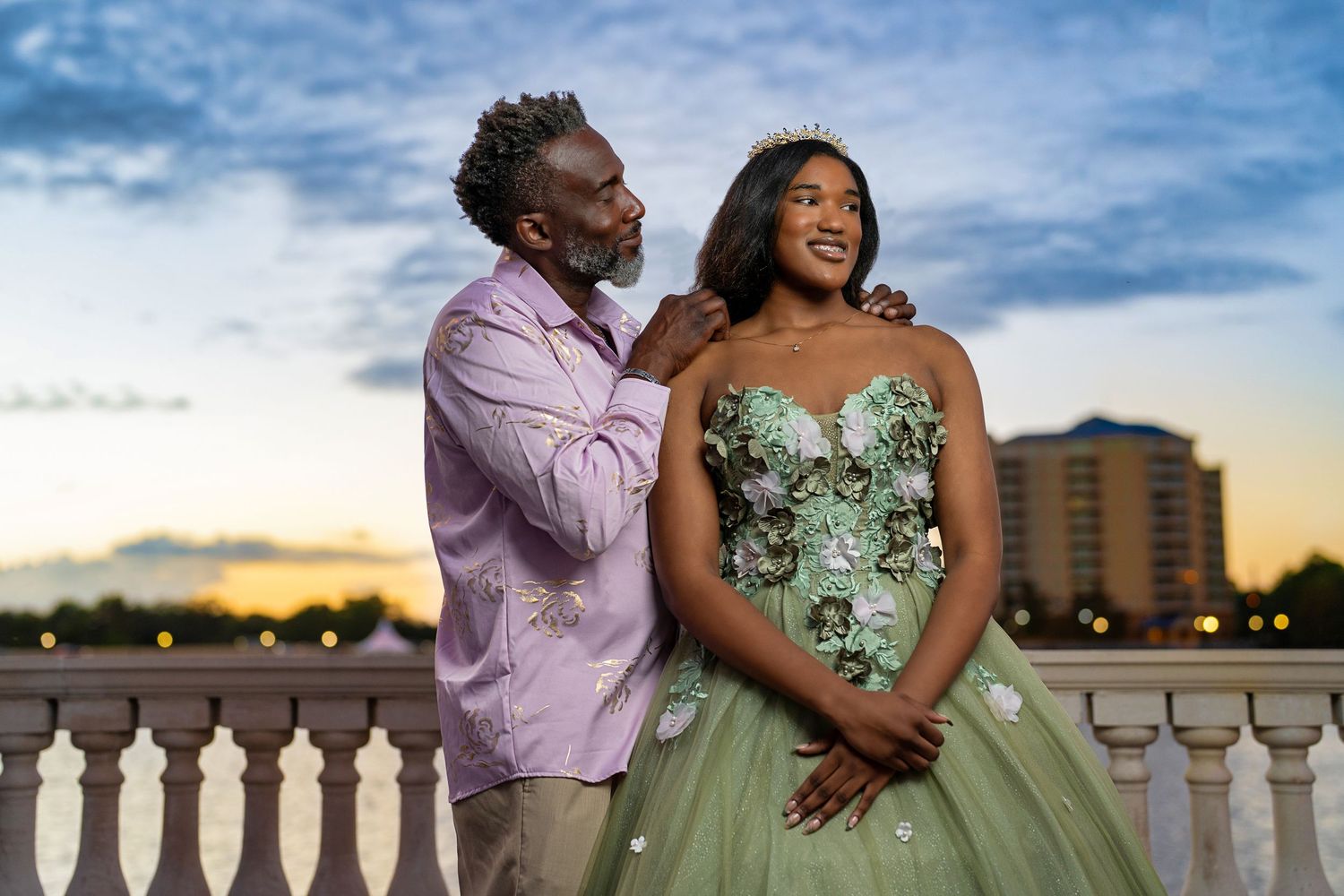Romantic sunset photoshoot featuring mint green ball gown against architectural backdrop.