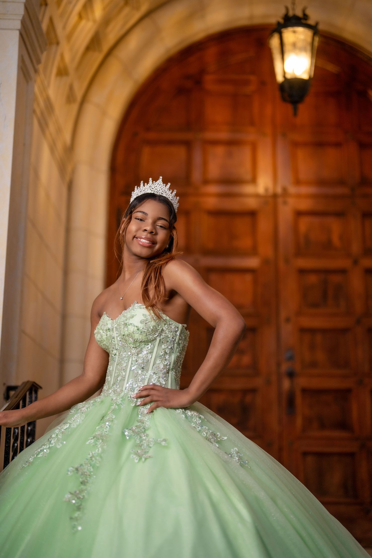 Dreamy mint green ball gown with beaded bodice captured in dramatic archway lighting.