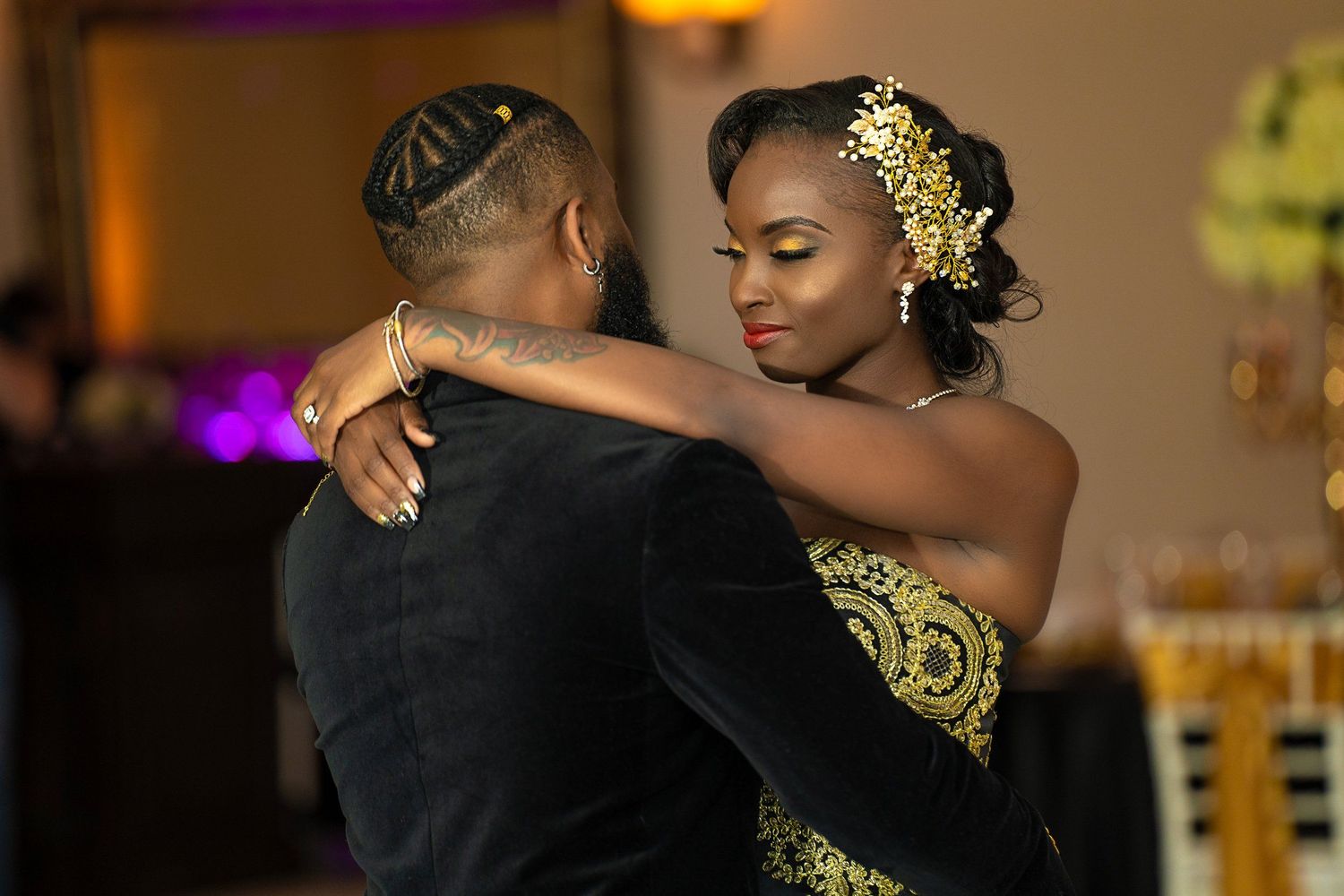 Elegant couples dancing at formal event with warm ambient lighting.