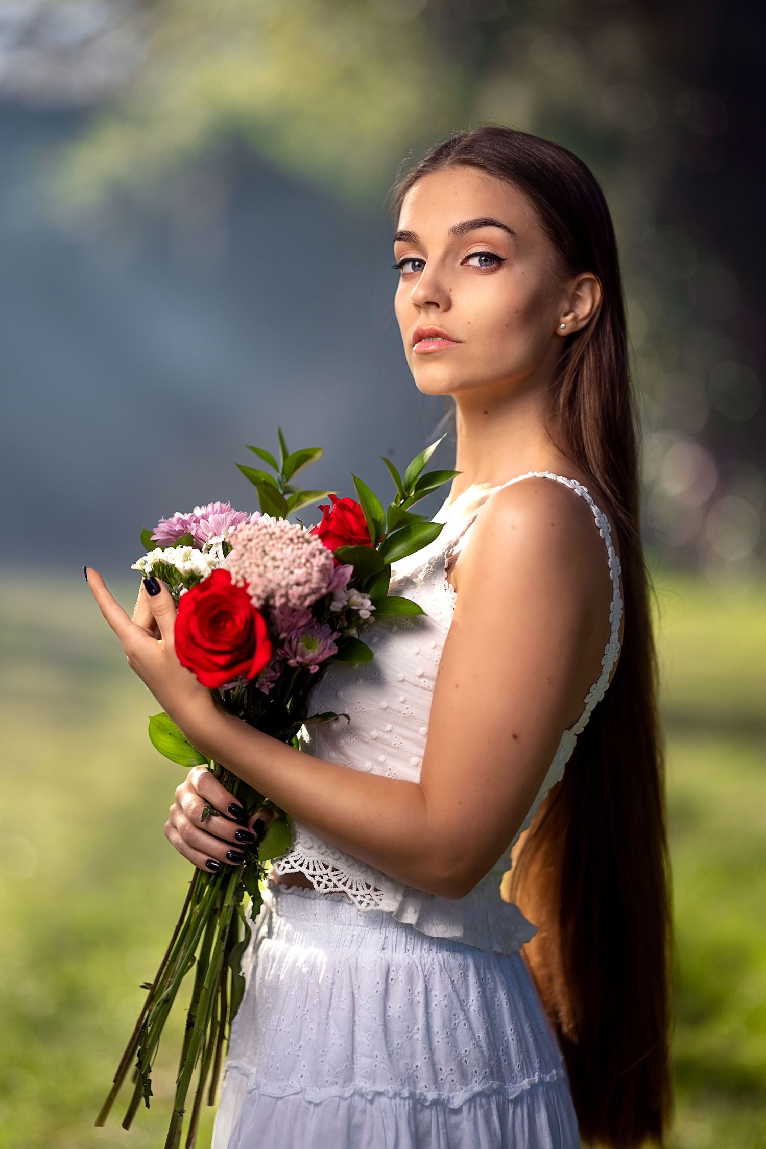 White lace dress and floral bouquet captured in dreamy outdoor portrait session.