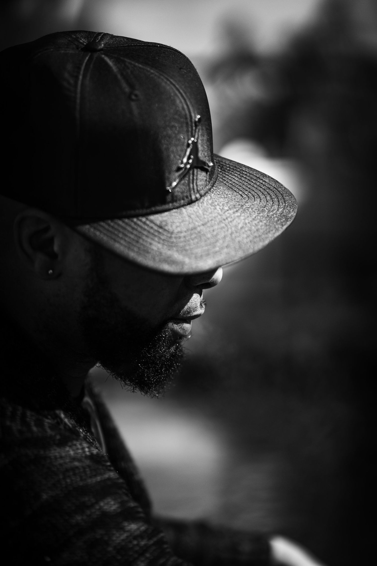 Artistic black and white profile shots featuring baseball cap and dramatic shadows.