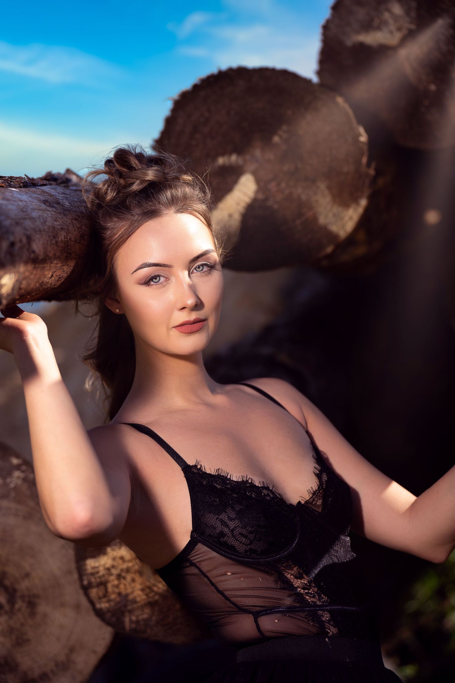 Artistic boudoir photography session with dramatic lighting and dark tones.