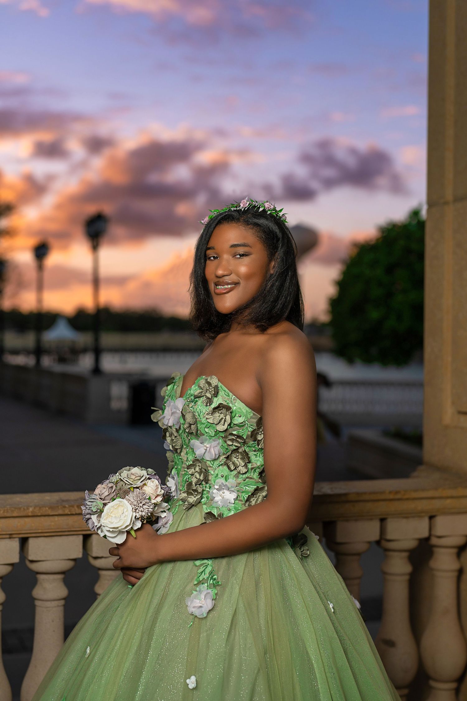 A mint green ball gown with floral details captured during golden hour.
