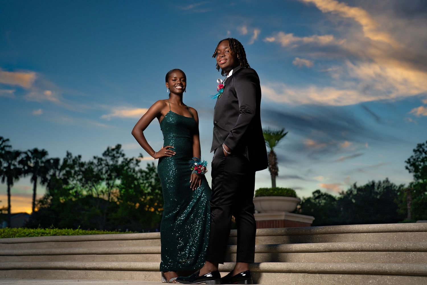 Elegant couple poses in formal attire during outdoor sunset photography session.