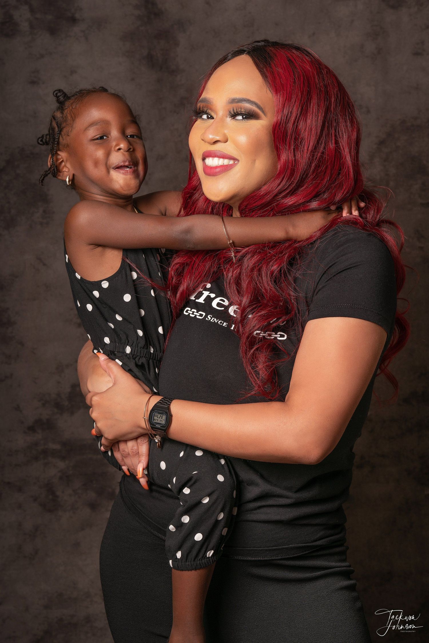A heartwarming portrait of two people sharing a joyful moment against a dark background.