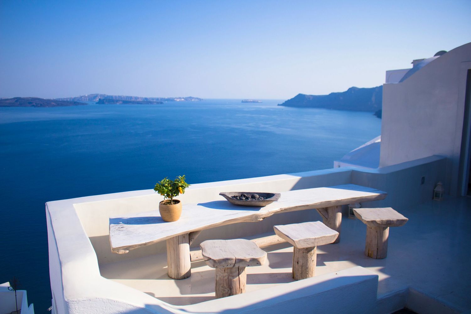 Stunning white terraces and seating areas overlooking the blue Mediterranean Sea in Santorini, Greece.