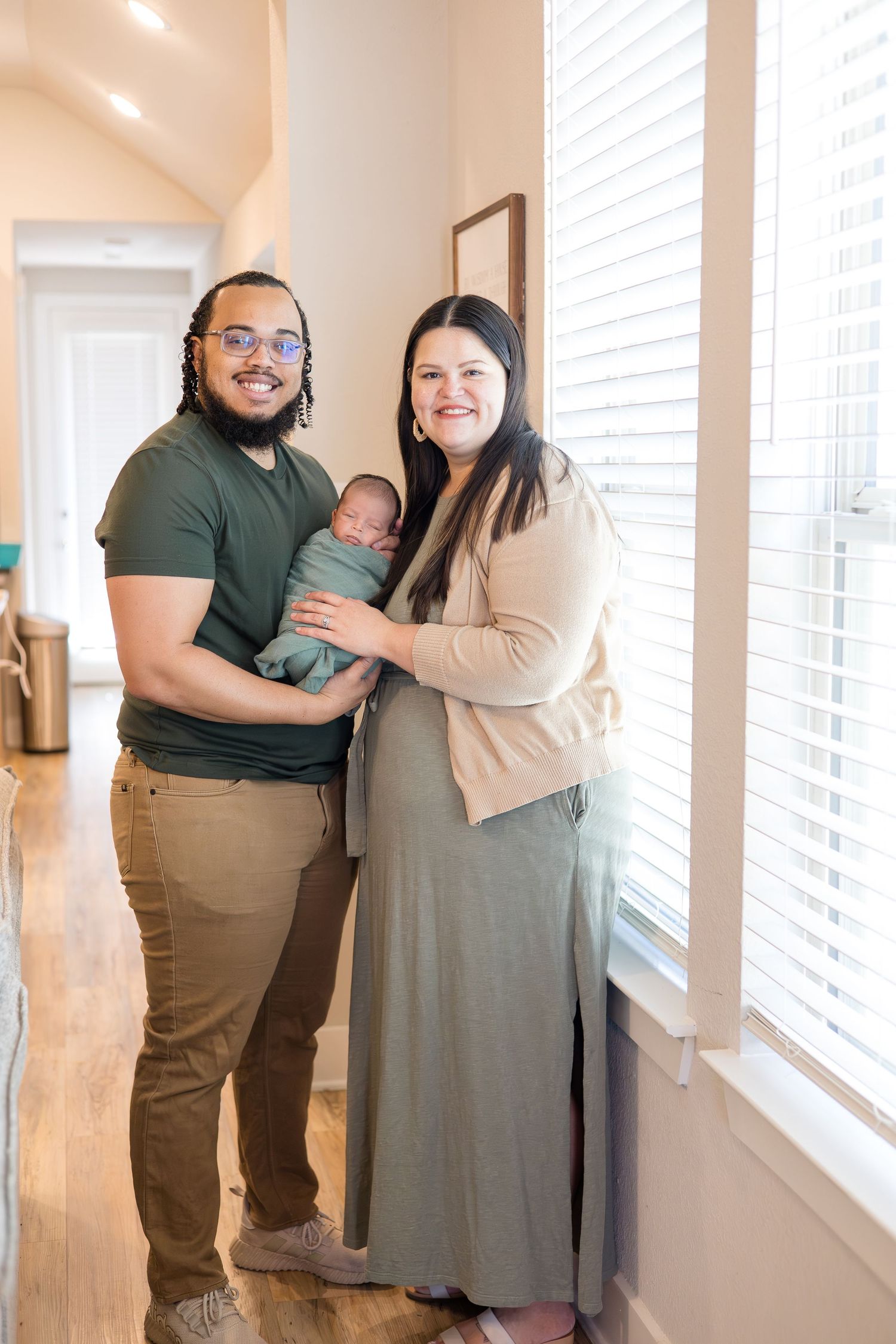 Mom and dad hold newborn during baby during in home lifestyle newborn session with McKinney Photographer Reagan Marie photography