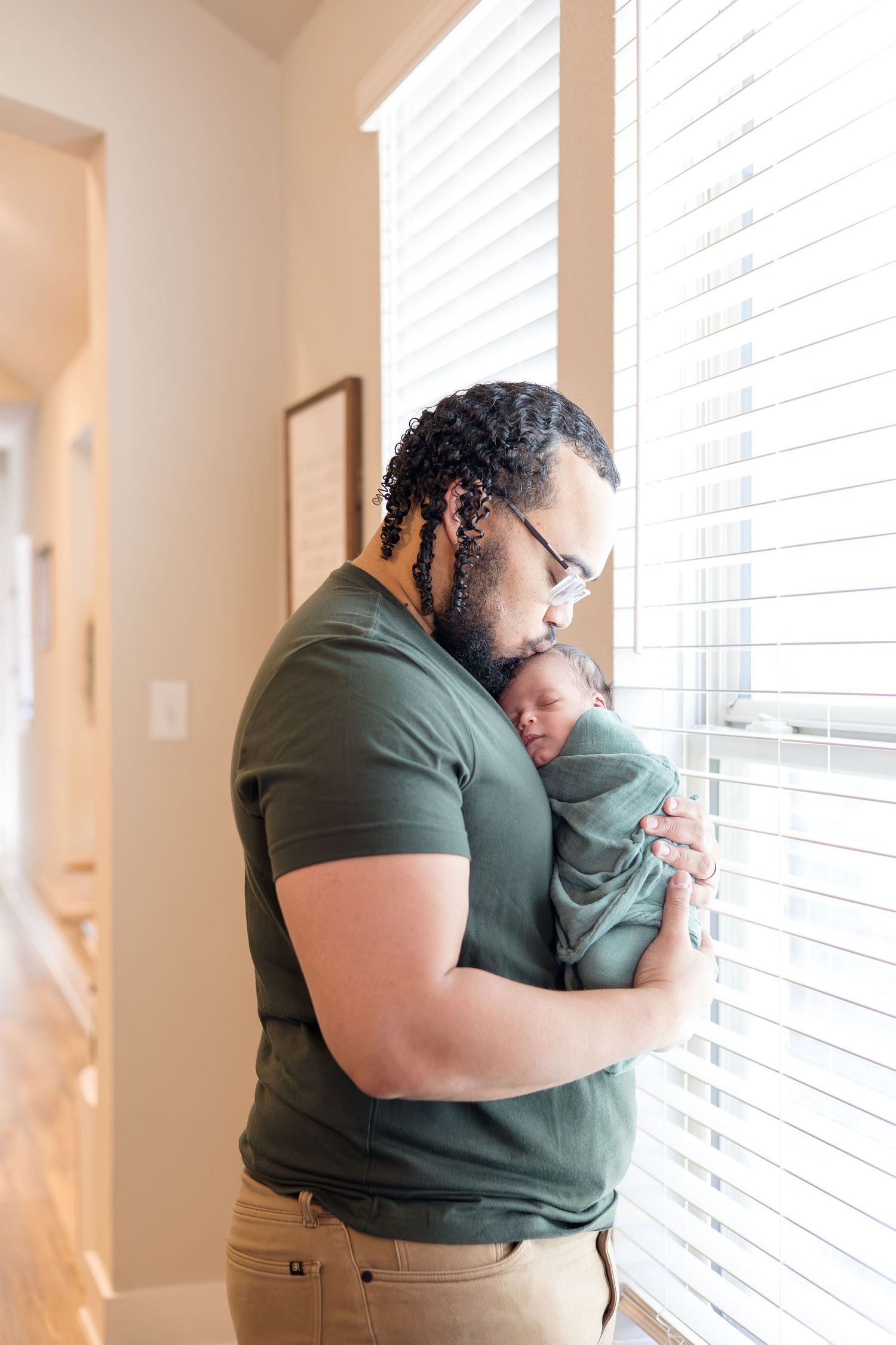 dad holds newborn son during in home lifestyle newborn session with McKinney Photographer Reagan Marie Photography based in McKinney, TX
