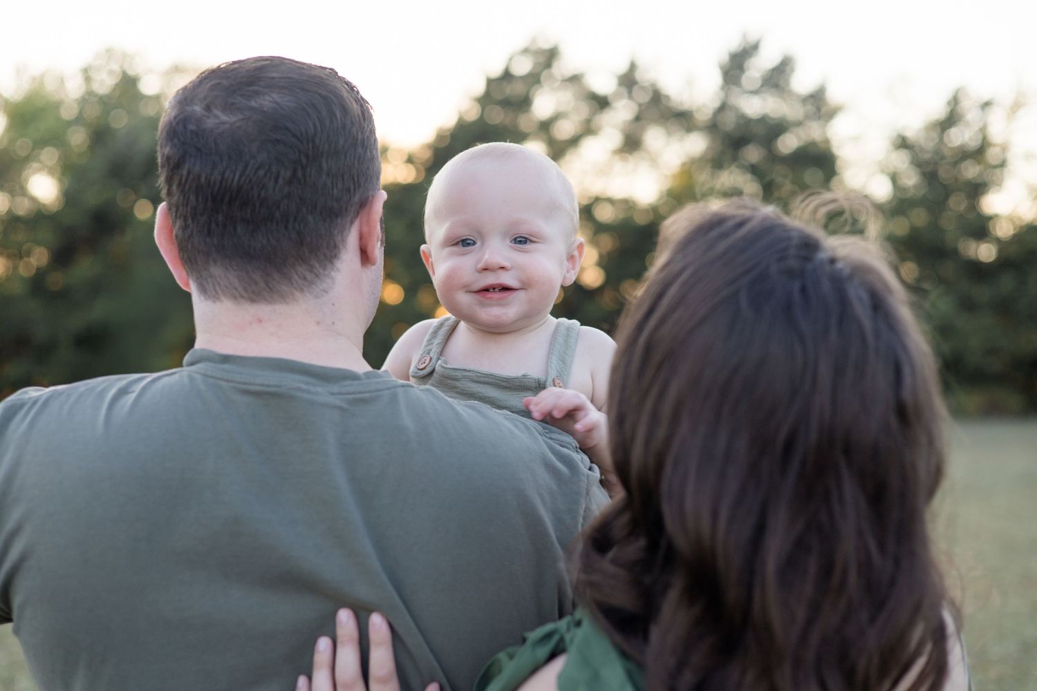 Couple holds son during McKinney family session with McKinney Family Photographer at Erwin Park during golden hour