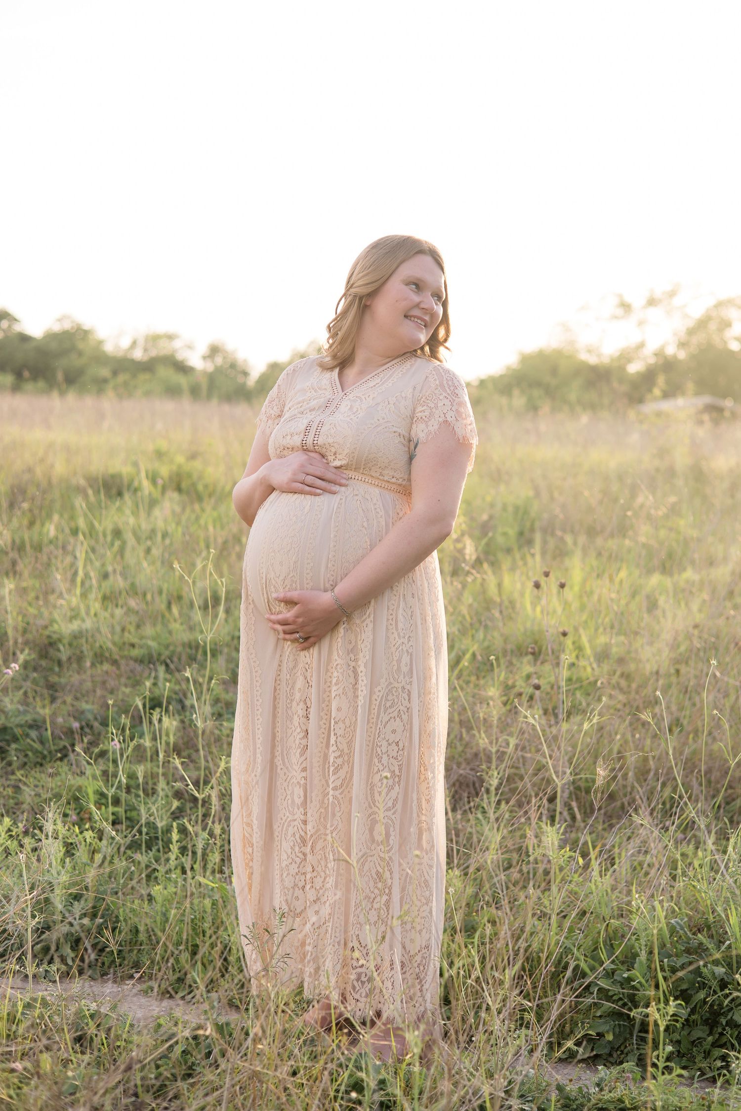 mom looks over shoulder posing for maternity session at erwin park in mckinney texas with dallas maternity photographer