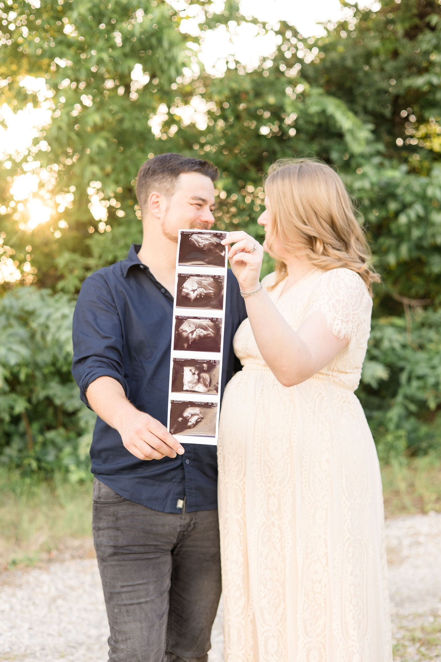 parents hold sonogram photo during maternity session at erwin park in mckinney texas with mckinney family photographer