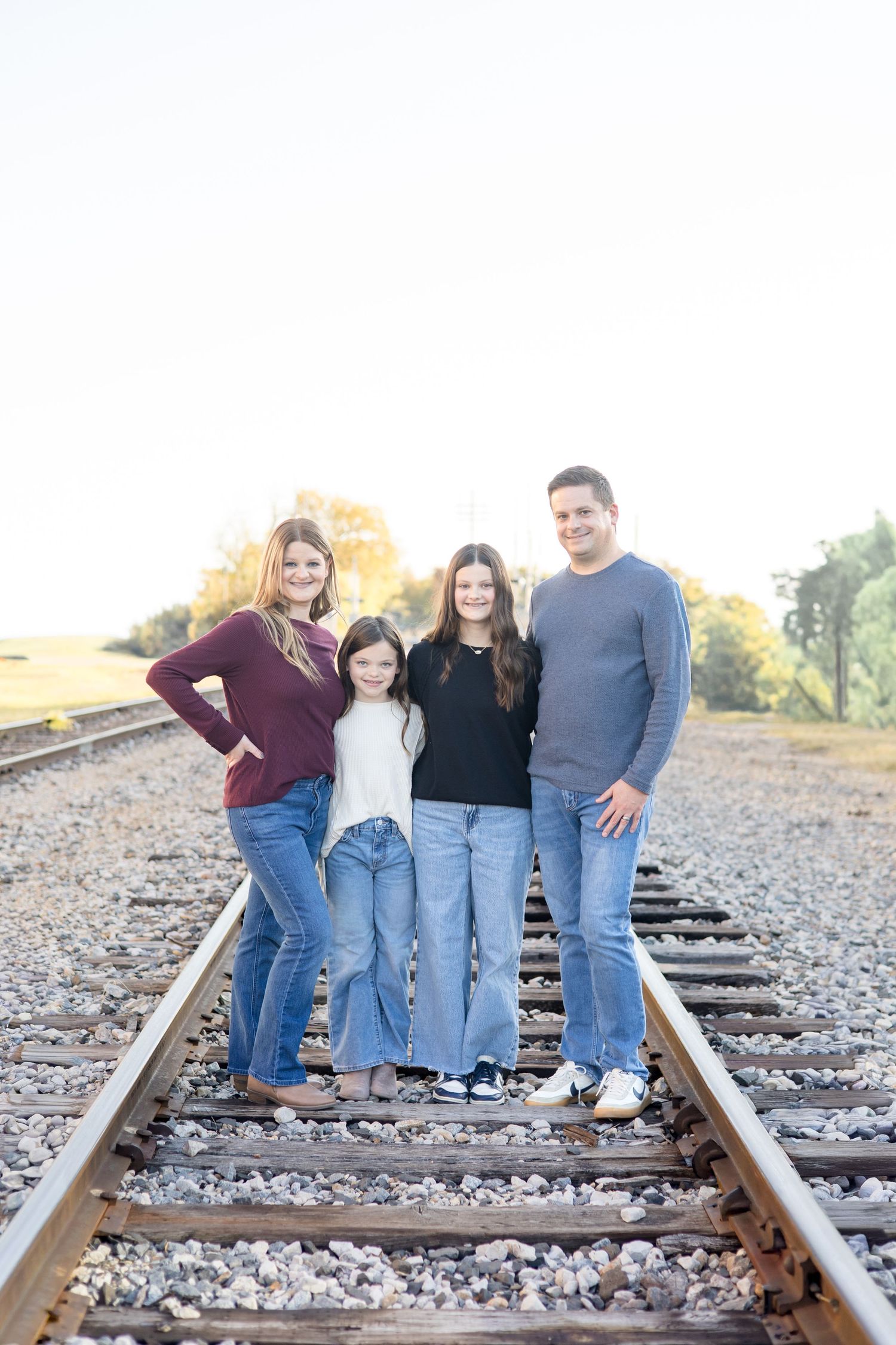 Family of 4 poses near downtown McKinney during family portrait session with McKinney Family Photographer Reagan Marie Photography