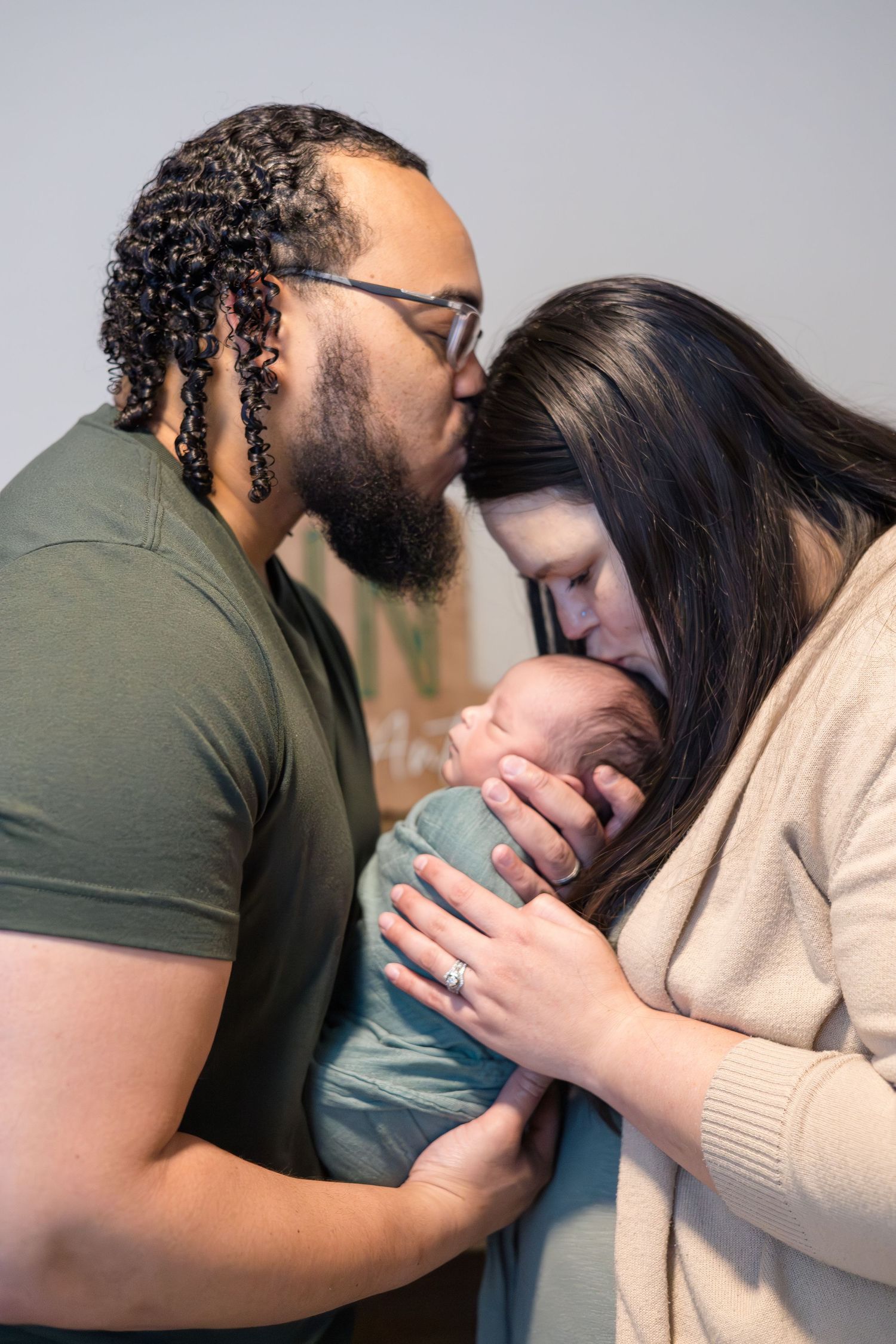 Mom and dad hold newborn during baby during in home lifestyle newborn session with McKinney Photographer Reagan Marie photography