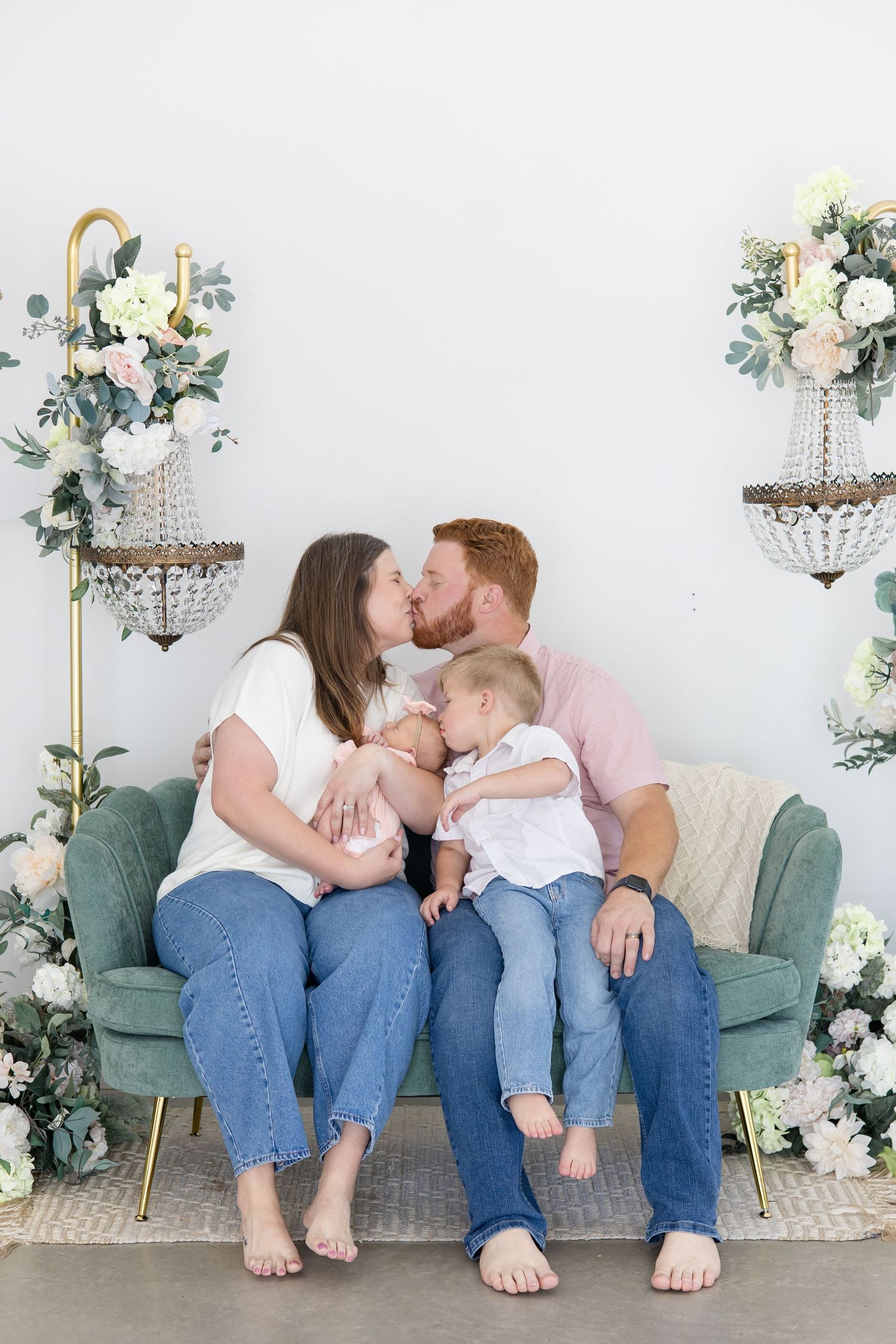 Mom and dad and siblings kiss during lifestyle newborn session with family photographer based out of McKinney Texas