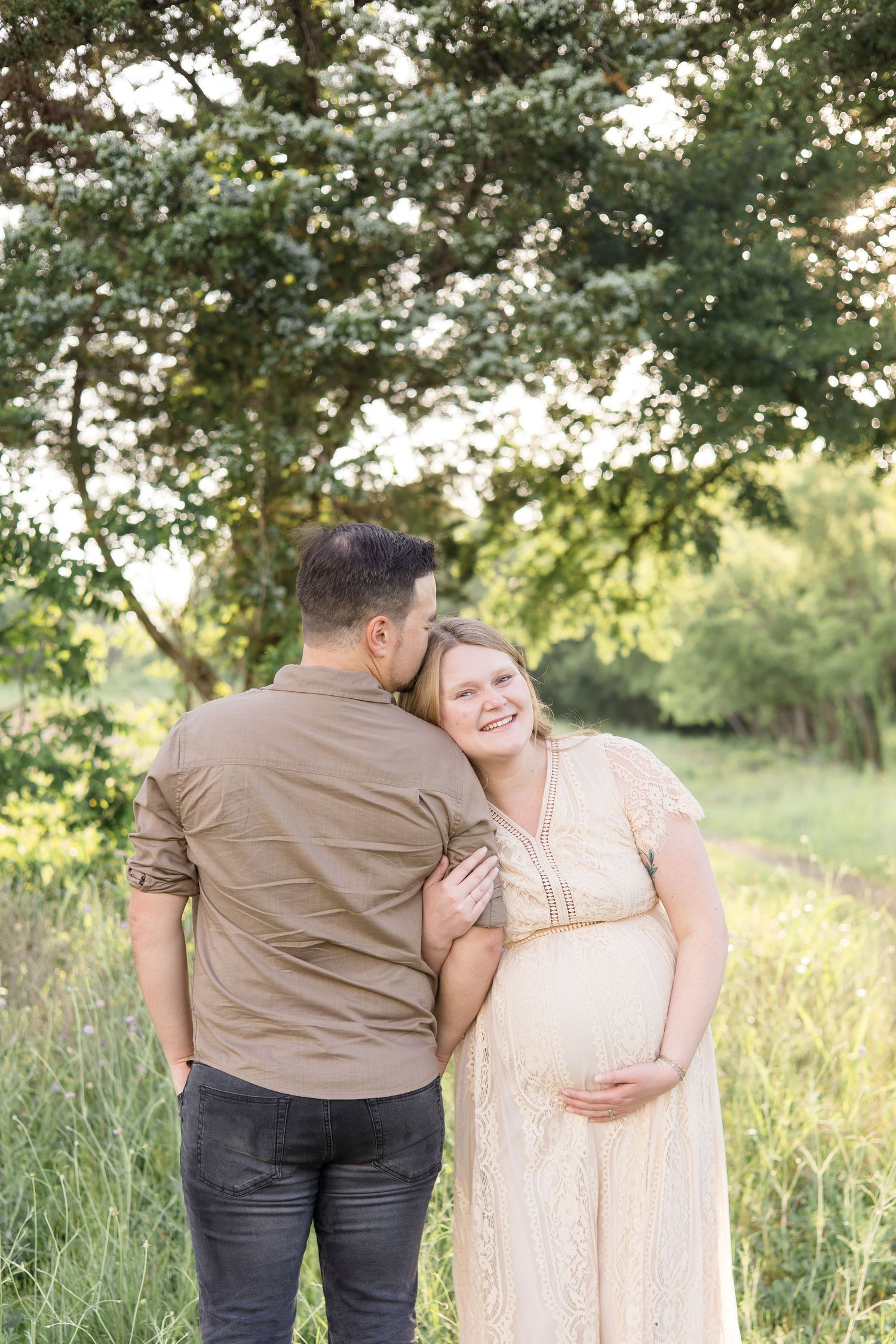 expecting parents pose under tree during golden hour maternity session with maternity photographer at erwin park in mckinney texas