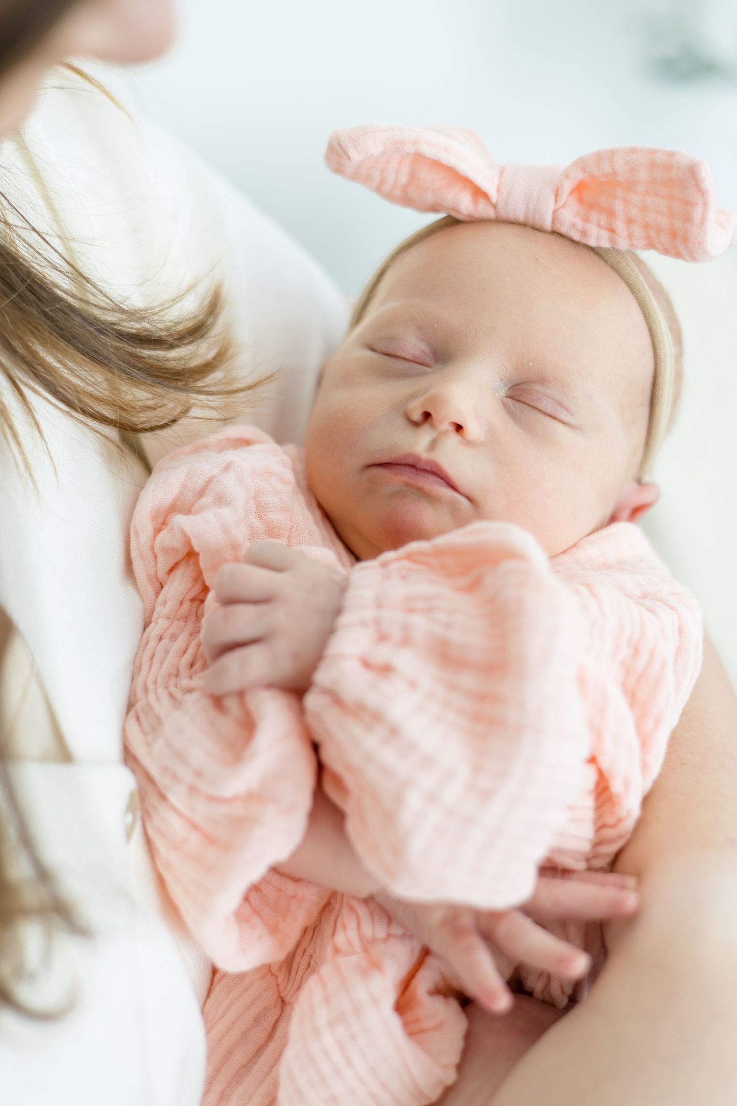 Mom holds newborn baby girl during lifestyle newborn session in the summer at Lemon Drop Studio with McKinney newborn photographer