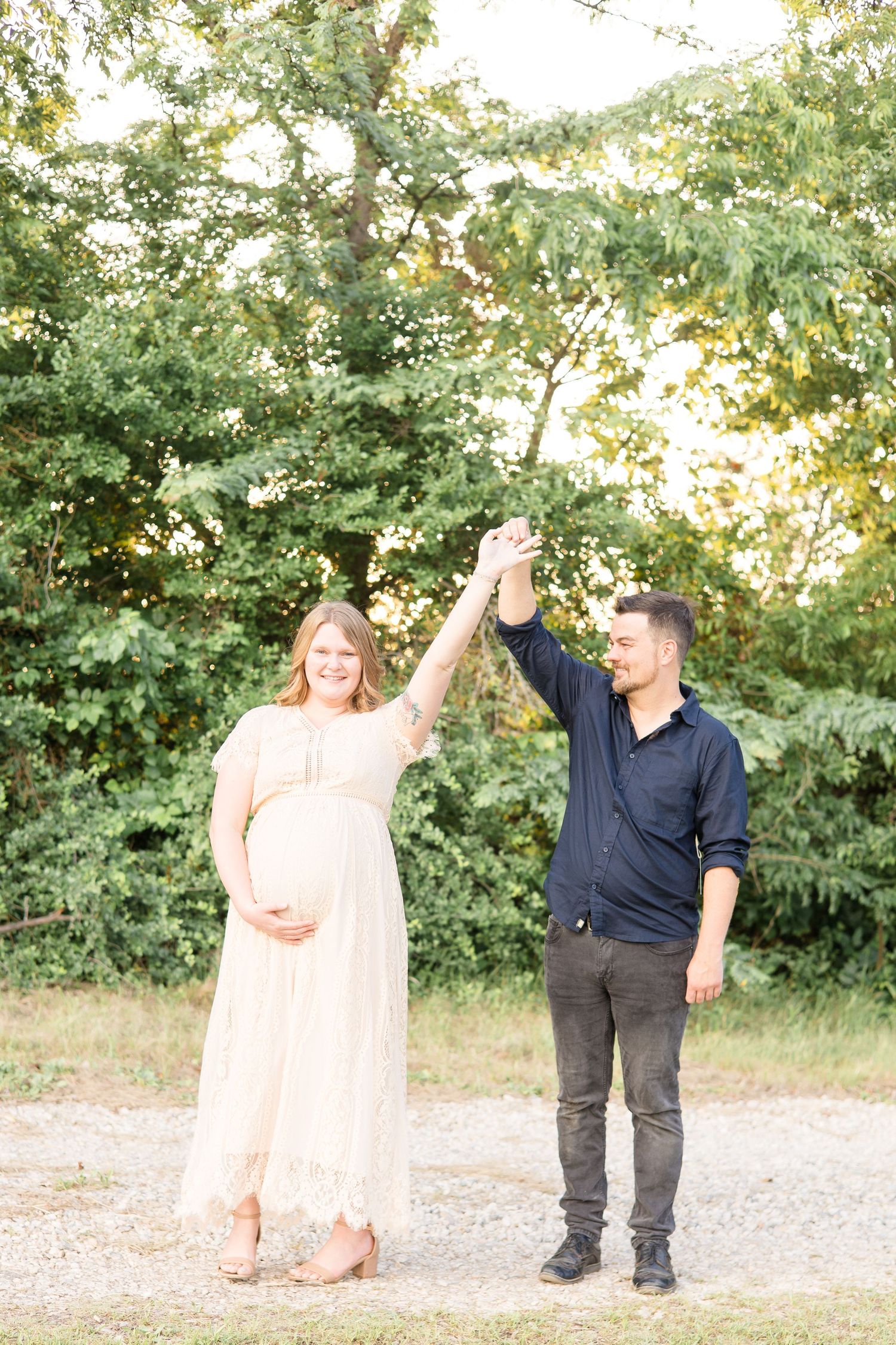 mom and dad dance in open field during golden hour during maternity session with mckinney family photographer