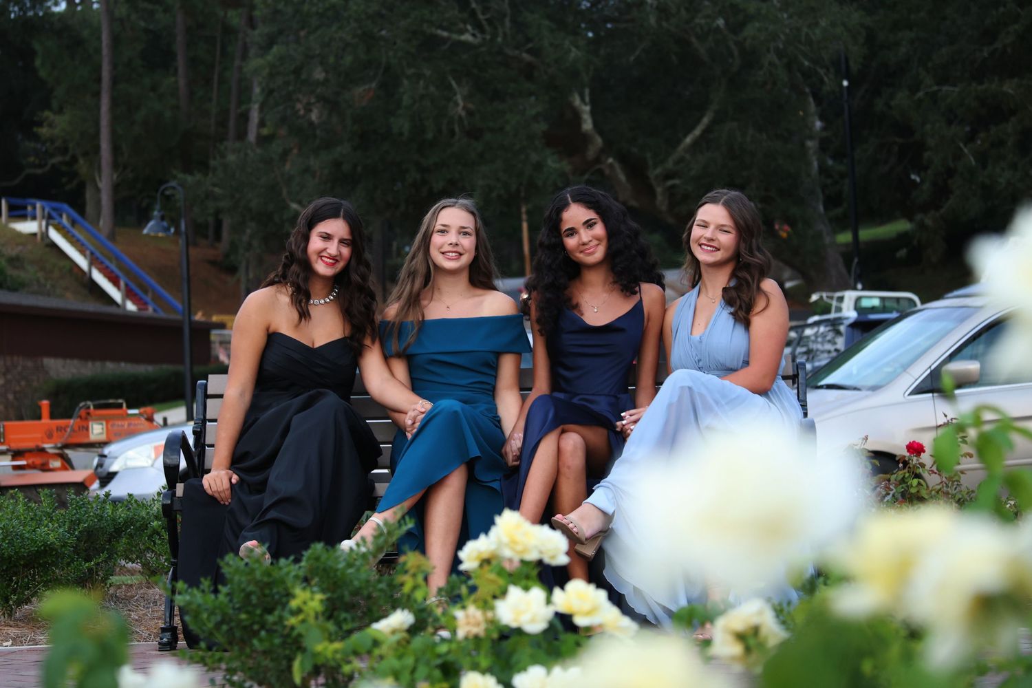 Four girls sitting on a bench framed with flowers