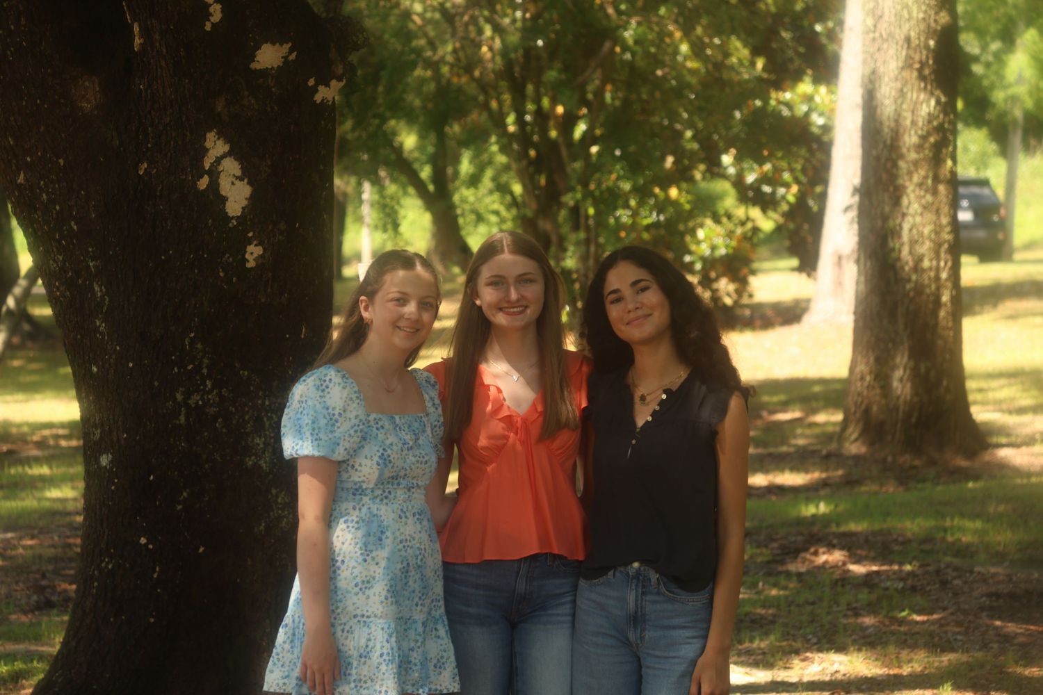 Three girls in a wooded background