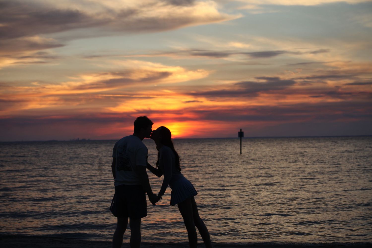 A silhouette of a couple kissing
